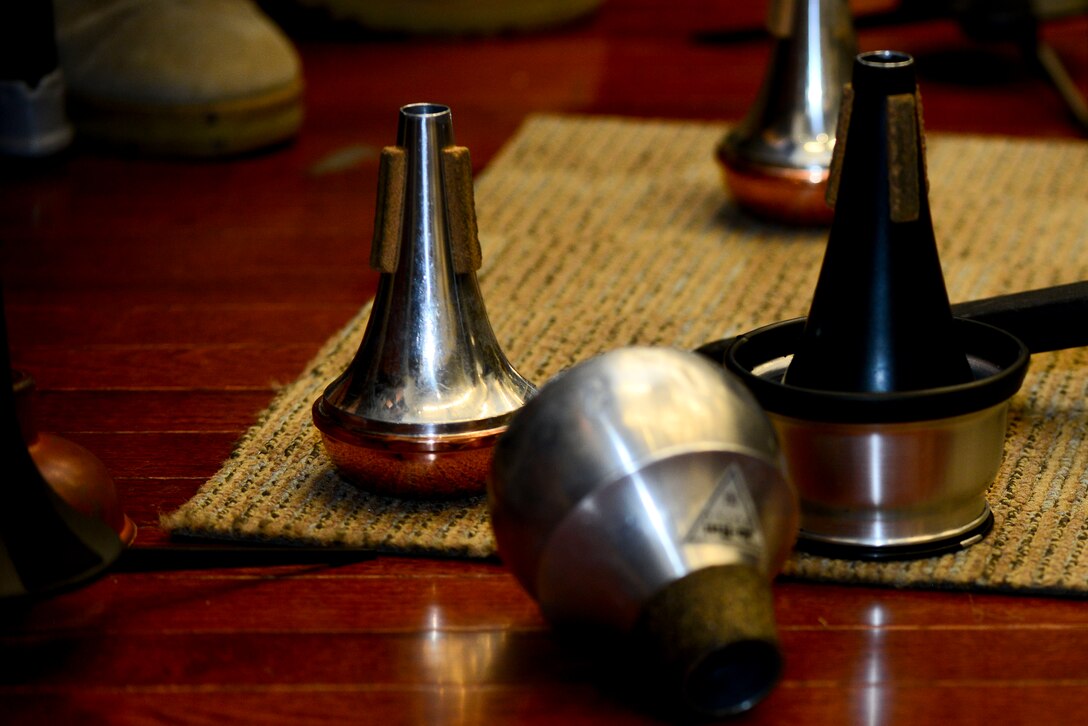 The U.S. Army Training Doctrine and Command Band concert band trumpet section use mutes to change or mute their instruments sound at Fort Eustis, Va., June 1, 2015. The band was rehearsing several selections they will play throughout the next three months as part of their summer concert series, “Music Under the Stars,” beginning June 4. (U.S. Air Force photo by Senior Airman Kimberly Nagle/Released)  