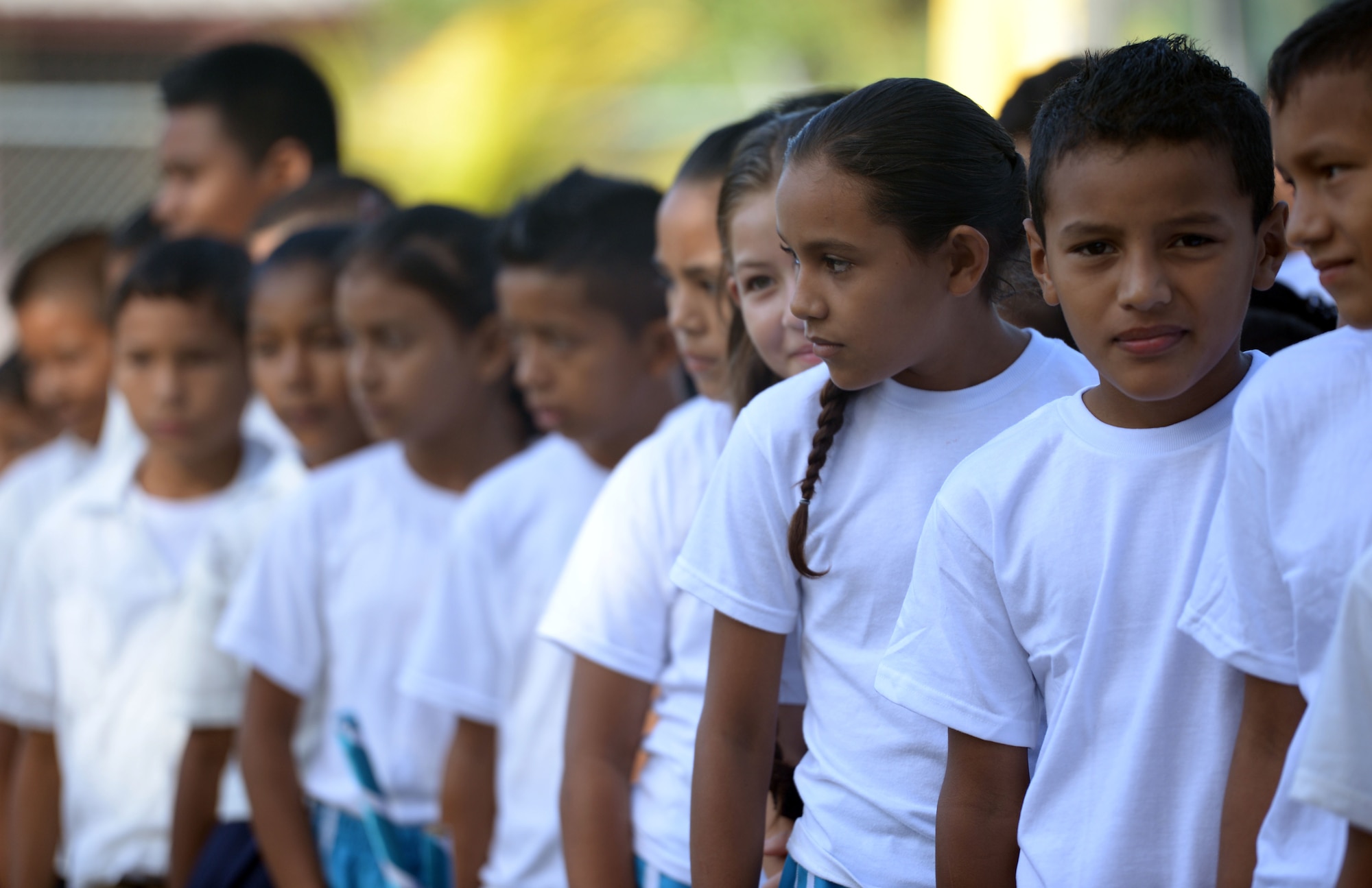 Gabirela Mistral students watch the groundbreaking ceremony at the Gabriela Mistral school in Ocotoes Alto, Honduras, June 1, 2015. The children performed a number of dance routines as part of the ceremony which also marked the first day of the New Horizons Honduras 2015 training exercise taking place in and around the Trujillo and Tocoa areas. New Horizons was launched in the 1980s and is an annual joint humanitarian assistance exercise that U.S. Southern Command conducts with a partner nation in Central America, South America or the Caribbean. The exercise improves joint training readiness of U.S. and partner nation civil engineers, medical professionals and support personnel through humanitarian assistance activities. (U.S. Air Force photo by Capt. David J. Murphy/Released)