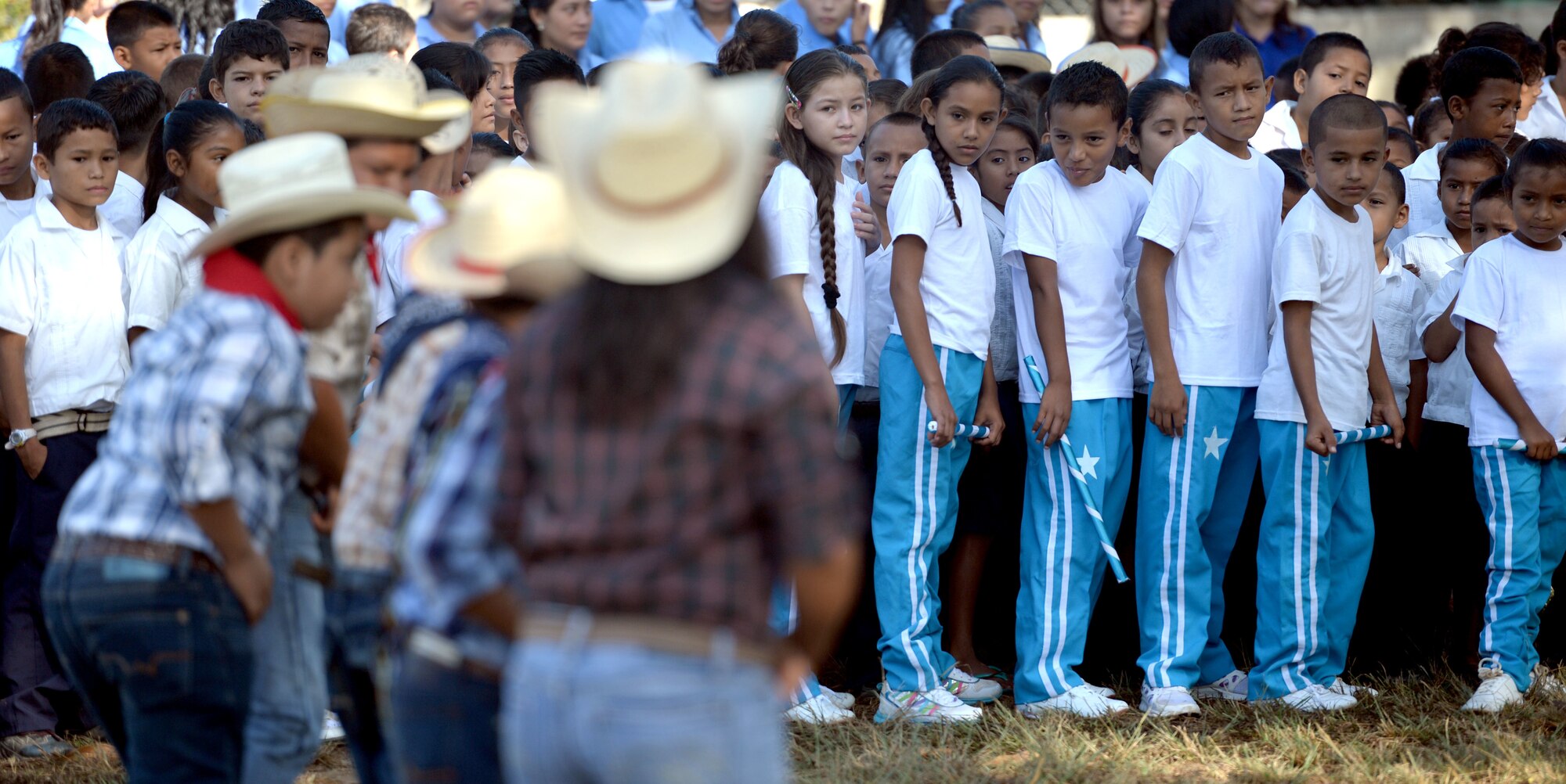 Gabriala Mistral students watch as their fellow students perform a traditional dance during the groundbreaking ceremony on the Gabriela Mistral school grounds in Ocotoes Alto, Honduras, June 1, 2015. The groundbreaking celebrated the beginning of construction on a new two-classroom building and marked the beginning of the New Horizons Honduras 2015 training exercise taking place in and around the Trujillo and Tocoa areas. New Horizons was launched in the 1980s and is an annual joint humanitarian assistance exercise that U.S. Southern Command conducts with a partner nation in Central America, South America or the Caribbean. The exercise improves joint training readiness of U.S. and partner nation civil engineers, medical professionals and support personnel through humanitarian assistance activities. (U.S. Air Force photo by Capt. David J. Murphy/Released)