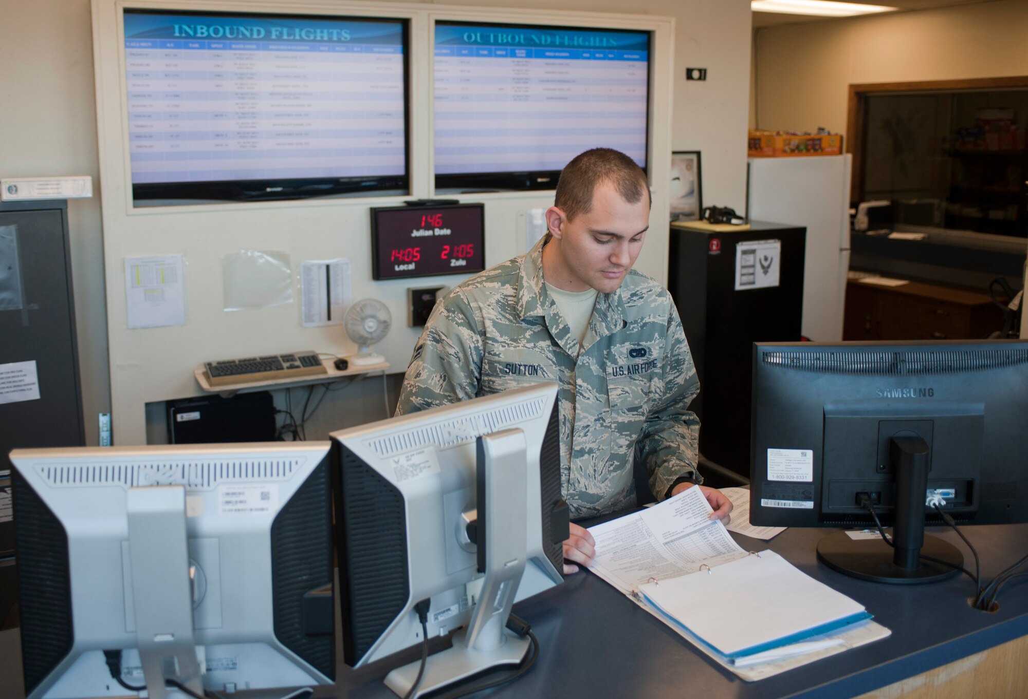 Airman 1st Class Jourdan Sutton, 99th Logistics Readiness Squadron air terminal operator, checks the flight schedule at the air terminal on Nellis Air Force Base, Nev., May 26, 2015. Space-available flights are available to veterans, Guard, Reserve and active-duty service members. Dependents must be accompanied by their sponsor. (U.S. Air Force photo by Airman 1st Class Mikaley Towle)