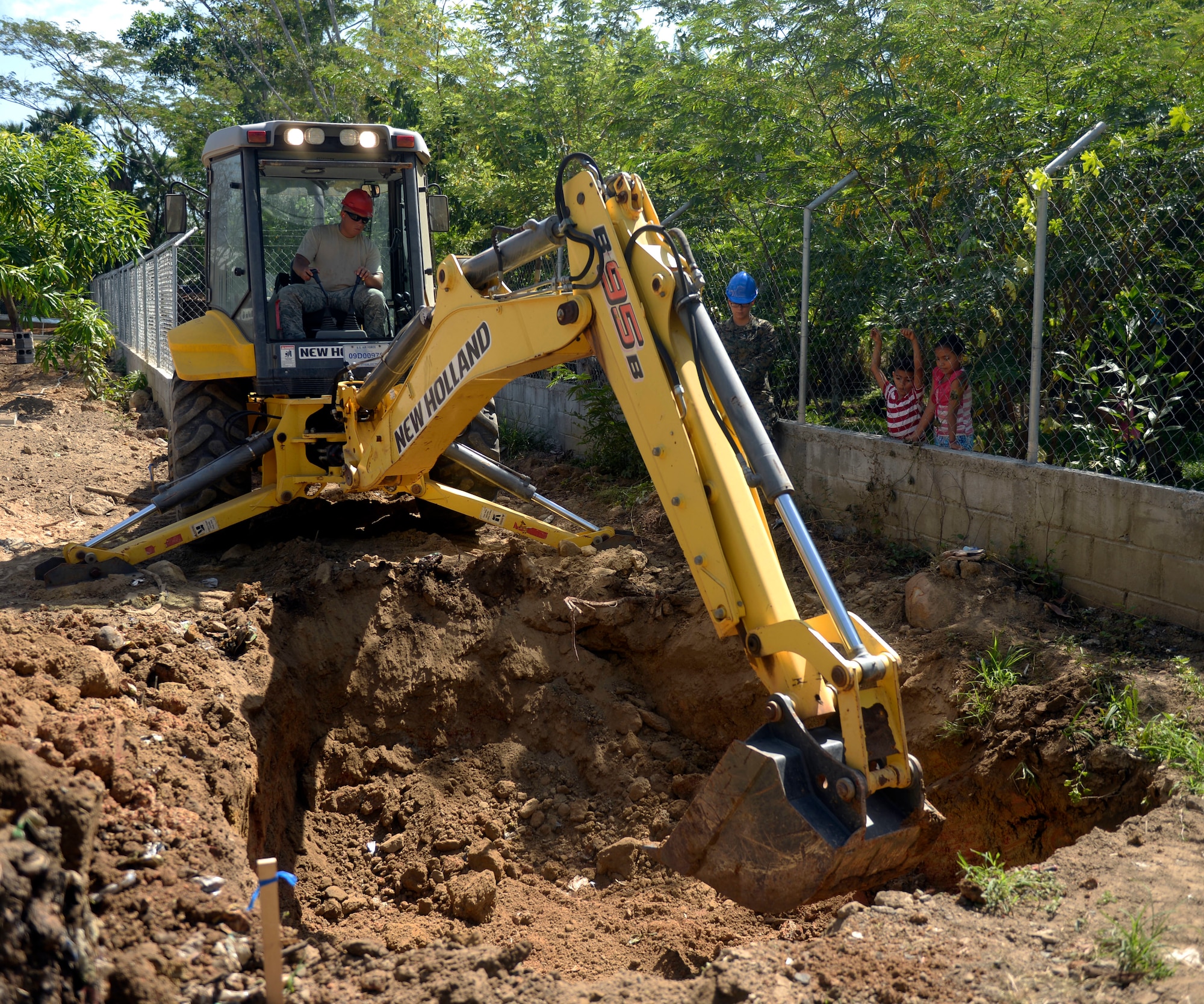 U.S. Air Force Staff Sgt. Michael Zemke, 823rd Expeditionary RED HORSE Squadron, out of Hurlburt Field, Fla., pavements and heavy equipment operator and Hilo, Hawaii native, move dirt for a septic system at the Gabriela Mistral primary school in Ocotoes Alto, Honduras, June 1, 2015. The school project is one part of the New Horizons Honduras 2015, an annual humanitarian and training exercise put on by U.S. Southern Command. New Horizons was launched in the 1980s and is an annual joint humanitarian assistance exercise that U.S. Southern Command conducts with a partner nation in Central America, South America or the Caribbean. The exercise improves joint training readiness of U.S. and partner nation civil engineers, medical professionals and support personnel through humanitarian assistance activities. (U.S. Air Force photo by Capt. David J. Murphy/Released)