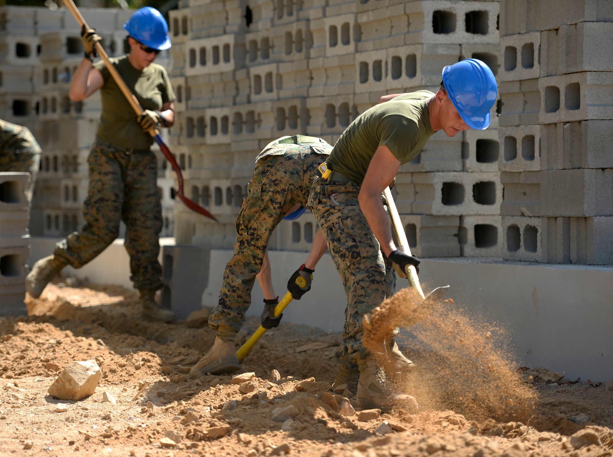 Marines from 271st Marine Wing Support Squadron, 2nd Marine Air Wing, out of Marine Corps Air Station Cherry Point, N.C., dig a trench for electrical wire around the exterior of the new school building being constructed at Gabriela Mistral primary school in Ocotoes Alto, Honduras, June 1, 2015. The Marines will be working with their Air Force counterparts from the 823rd Expeditionary RED HORSE Squadron out of Hurlburt Field, Fla., during exercise New Horizons Honduras 2015. New Horizons was launched in the 1980s and is an annual joint humanitarian assistance exercise that U.S. Southern Command conducts with a partner nation in Central America, South America or the Caribbean. The exercise improves joint training readiness of U.S. and partner nation civil engineers, medical professionals and support personnel through humanitarian assistance activities. (U.S. Air Force photo by Capt. David J. Murphy/Released)