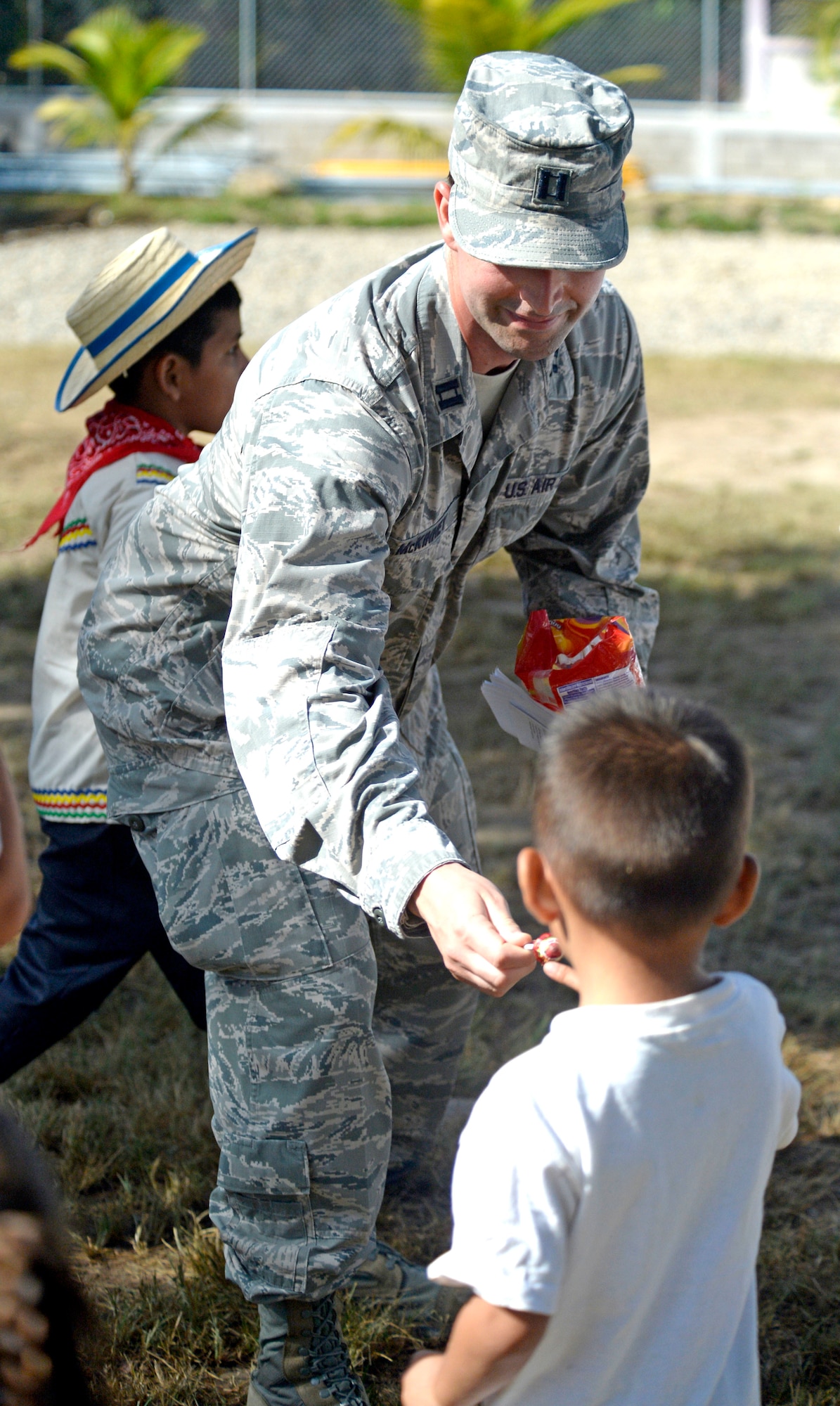 U.S. Air Force Capt. Austin McKinney, 8th Air Force Life Cycle Management Center deputy program manager out of Hanscom Air Force Base, Mass., and Canton, Mich. native, hands out candy to children following a groundbreaking ceremony at the Gabriela Mistral primary school in Ocotoes Alto, Honduras, June 1, 2015. McKinney provided translation services during the ceremony which signified the official start of the New Horizons Honduras 2015 training exercise. New Horizons was launched in the 1980s and is an annual joint humanitarian assistance exercise that U.S. Southern Command conducts with a partner nation in Central America, South America or the Caribbean. The exercise improves joint training readiness of U.S. and partner nation civil engineers, medical professionals and support personnel through humanitarian assistance activities. (U.S. Air Force photo by Capt. David J. Murphy/Released)