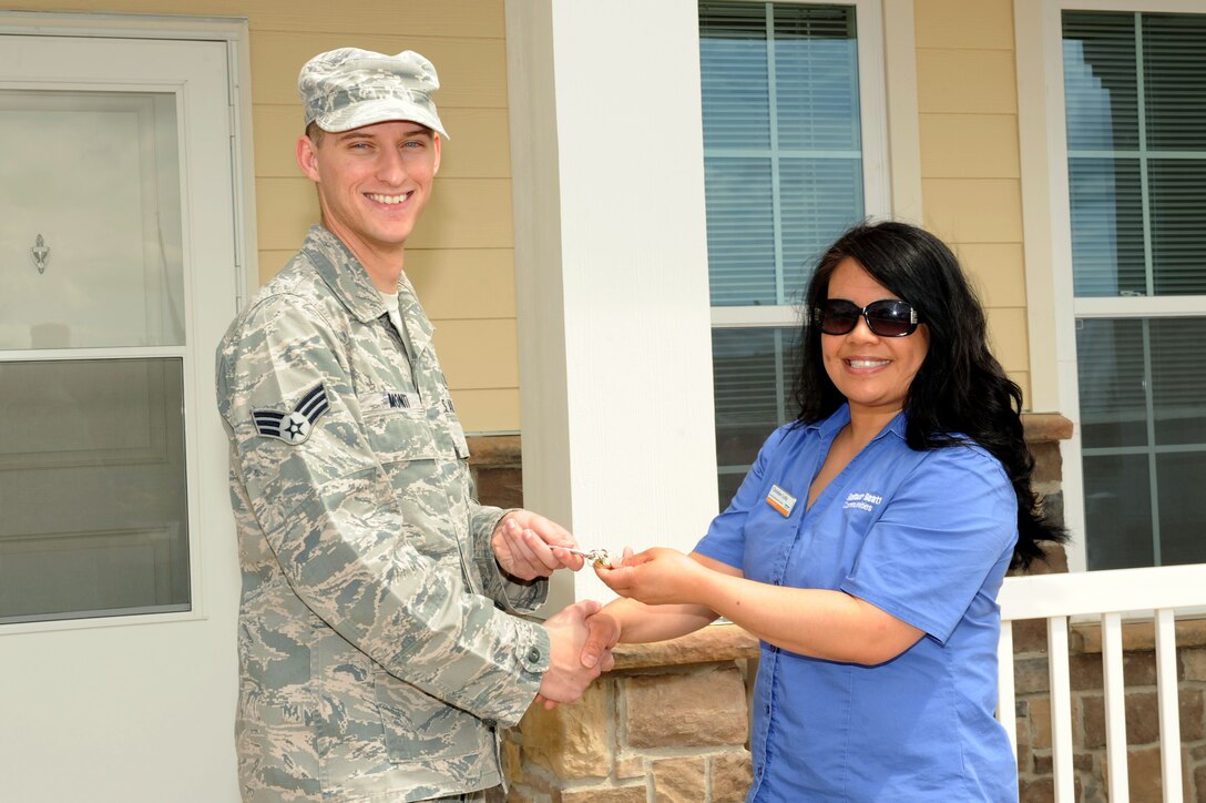 Senior Airman Dustin Monti, 28th Medical Operations Squadron bioenvironmental engineering technician, receives keys from Christine Lydic, Balfour Beatty Communities resident specialist, at Ellsworth Air Force Base, S.D., May 27, 2015. The privatized housing development BBC provides quality housing for many active-duty Airmen with dependents who wish to live on-base. (U.S. Air Force photo by Senior Airman Hailey R. Staker/Released)  
