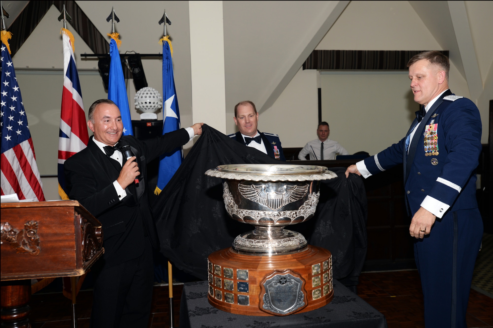 Jim Hvizd, vice president of Raytheon’s Space and Airborne Systems, left, Lt. Col. John Stratton, 493rd Fighter Squadron commander, center, and Gen. Frank Gorenc, U.S. Air Forces in Europe and Air Forces Africa commander, unveil the 2014 Raytheon Trophy during a celebration May 29, 2015. The 493rd FS received the trophy as the U.S. Air Force’s top fighter squadron, and previously won the award in 1997, 1999, and 2007. (U.S. Air Force photo by Tech. Sgt. Eric Burks/Released)