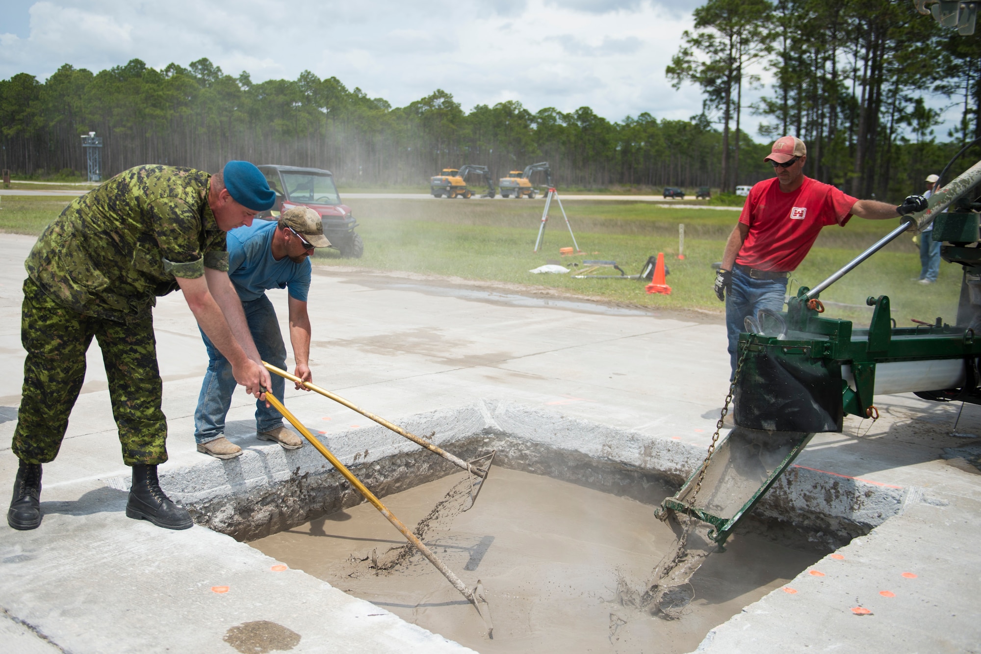 TYNDALL AIR FORCE BASE, Fla. -- Royal Canadian air force Warrant Officer David Hagan spreads flowable fill, a mixture used in place of compacted soil for some airfield repairs, during a demonstration at the Silver Flag Training Site here May 15. Members of the RCAF visited the Air Force Civil Engineer Center to discuss opportunities for using flowable fill for future repairs. (U.S. Air Force photo/Jess Echerri/Released)