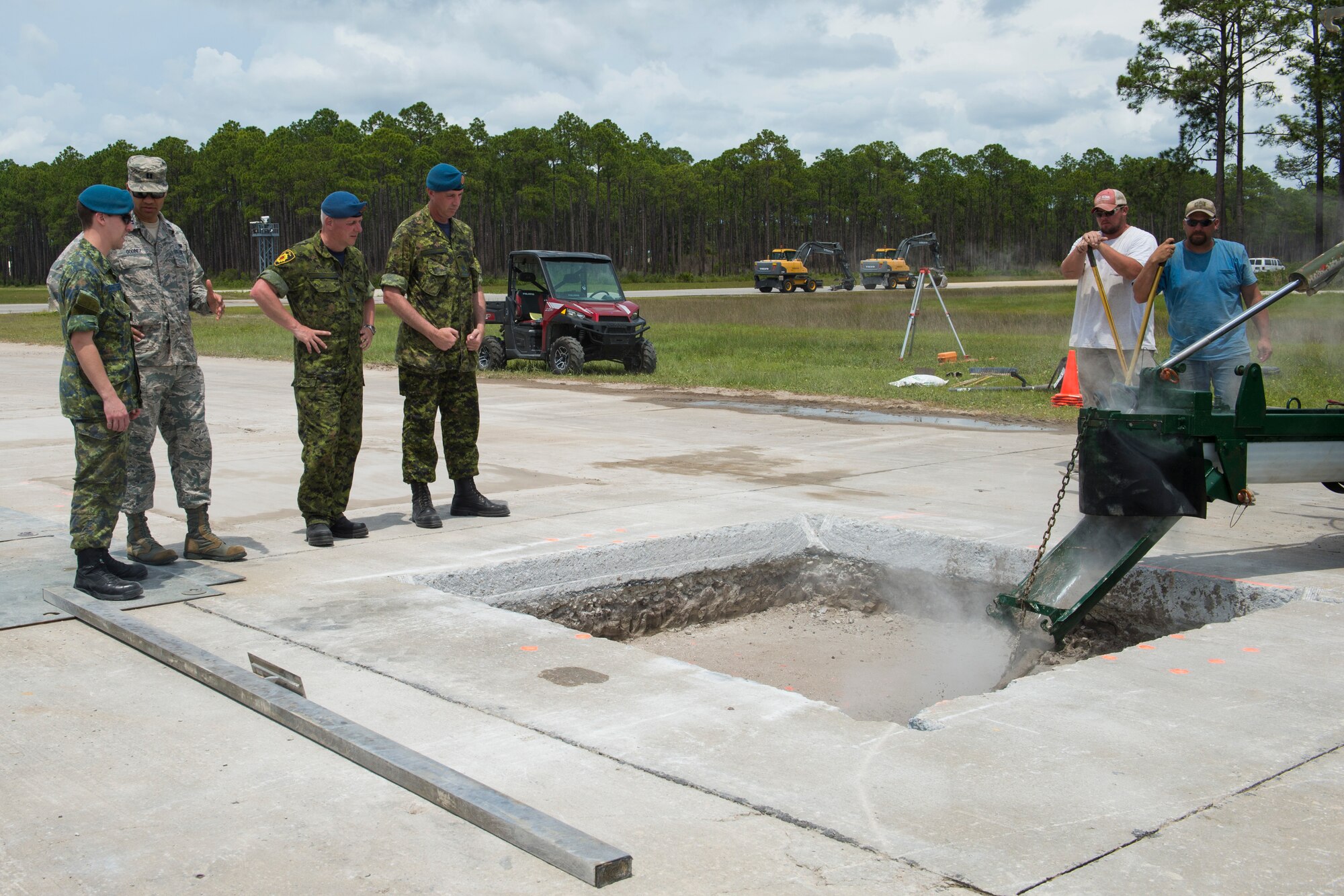 TYNDALL AIR FORCE BASE, Fla. -- Members of the Royal Canadian air force and U.S. Air Force watch a demonstration of a repair using flowable fill, a mixture used in place of compacted soil for some airfield repairs at the Silver Flag Training Site here. Members of the RCAF visited the Air Force Civil Engineer Center May 15 to discuss opportunities for using flowable fill. (U.S. Air Force photo/Jess Echerri/Released)