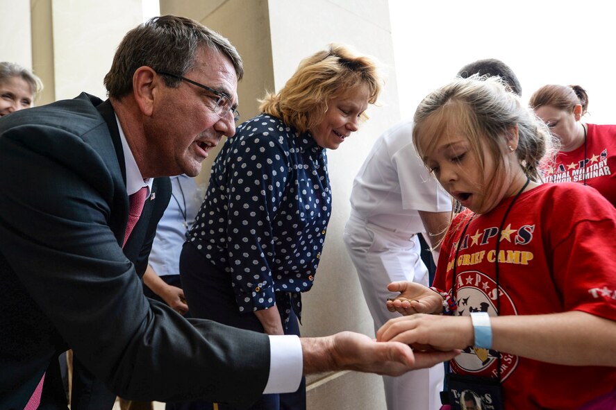 Defense Secretary Ash Carter presents challenge coins to members of the Tragedy Assistance Program for Survivors at the Pentagon, May 22, 2015. The Pentagon hosted the families for a night of fun and remembrance to mark Memorial Day. The program, known as TAPS, offers support for military families who have lost a family member serving in the military. (DoD photo by Navy Petty Officer 2nd Class Sean Hurt / Released)