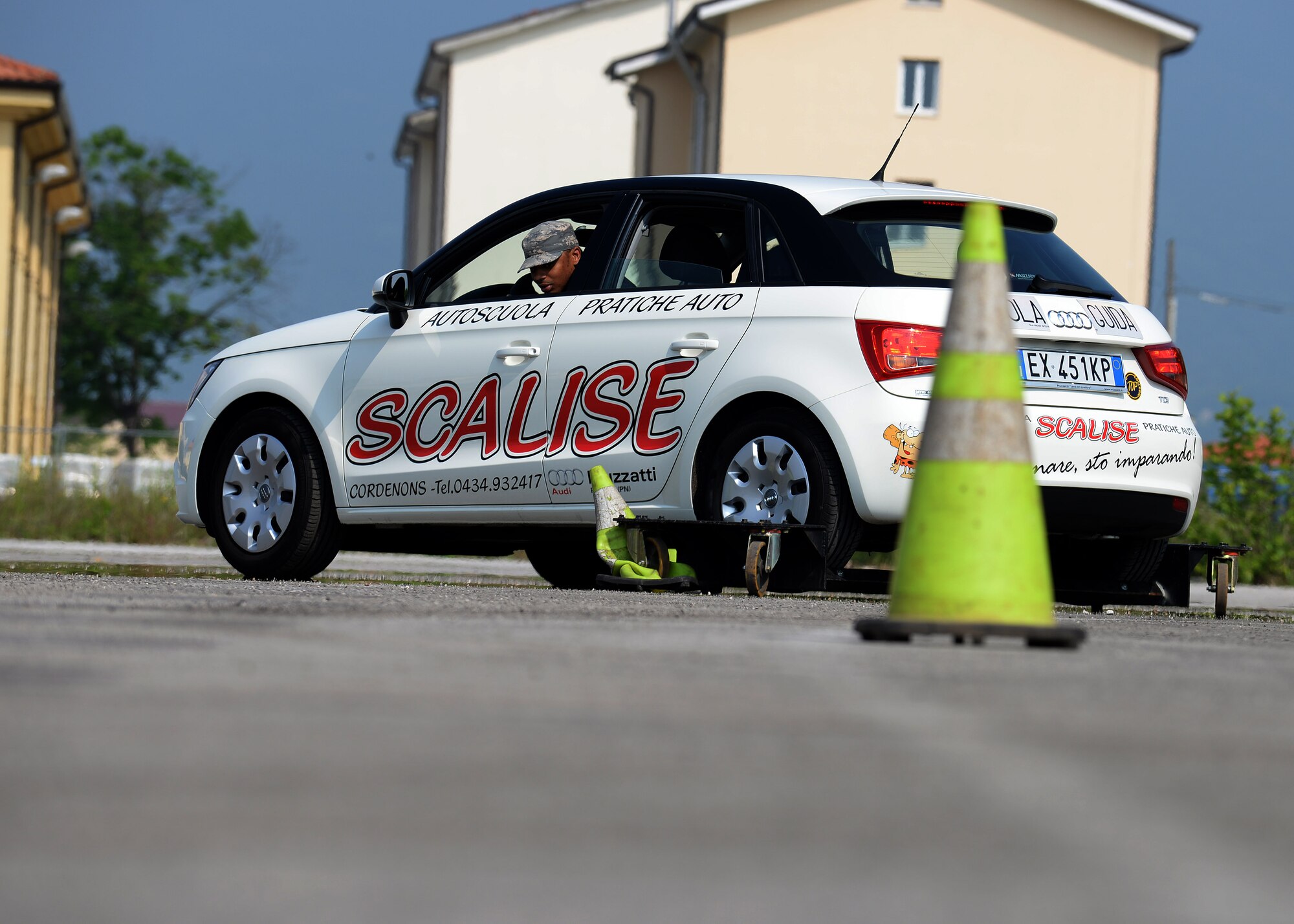 U.S. Air Force Staff Sgt. Brandon Skeete, 31st Operations Support Squadron mission weather forecaster, inspects a cone he ran over while navigating the skid car serpentine course, May 29, 2015, at Aviano Air Base, Italy. The course provided Airmen the opportunity to drive a vehicle in simulated adverse road conditions. Go-karts and a NASCAR show demonstration also helped kick off the 31st Fighter Wing Safety Office’s ‘Critical Days of Summer’ program. (U.S. Air Force photo by Airman 1st Class Cary Smith/Released)