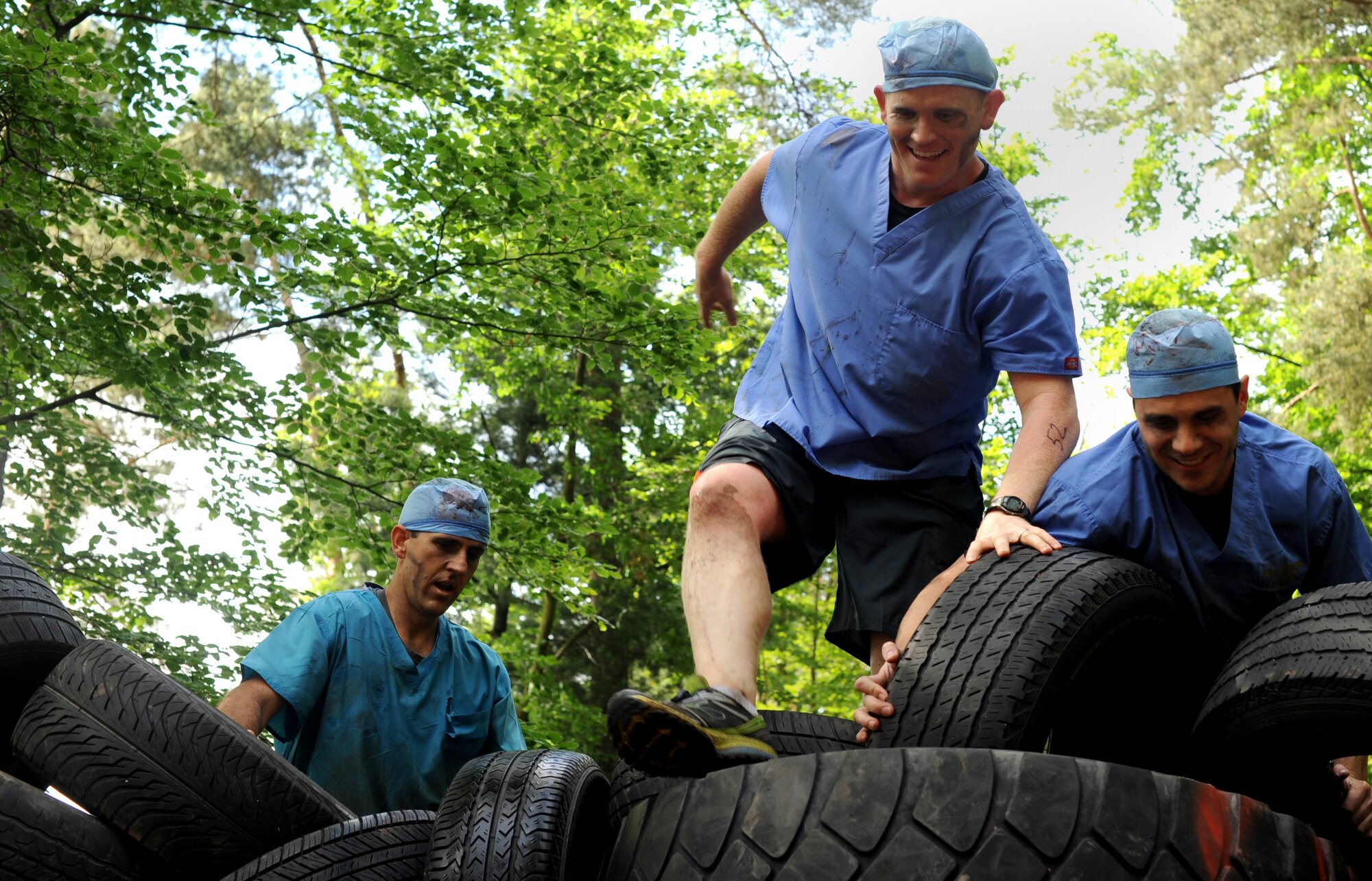 Members of team "Zombie Dentists" climb a tire wall during the Mudless Mudder event June 2, 2015, at Ramstein Air Base, Germany. Mudless Mudder was part of the 86th Airlift Wing's Resiliency Day, which gave participants the opportunity to spend time with others and build working relationships. (U.S. Air Force photo/Staff Sgt. Sharida Jackson)