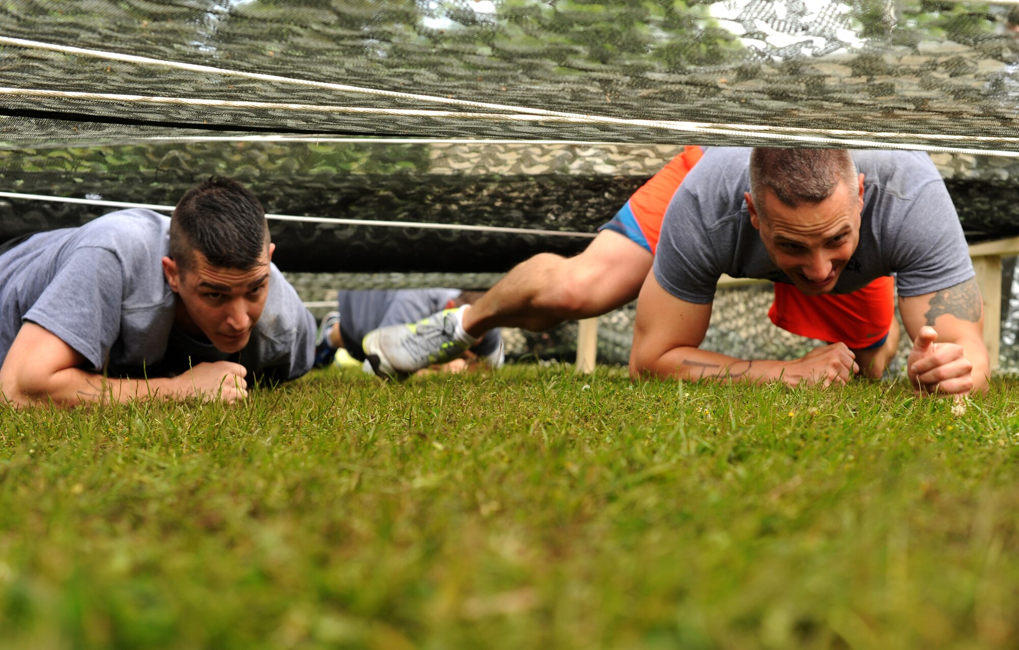 Members of team "Dirty Laundry" compete in the low crawl obstacle during the Mudless Mudder June 2, 2015, at Ramstein Air Base, Germany. Mudless Mudder was part of the 86th Airlift Wing's Resiliency Day, which gave participants the opportunity to spend time with others and build working relationships. (U.S. Air Force photo/Staff Sgt. Sharida Jackson)