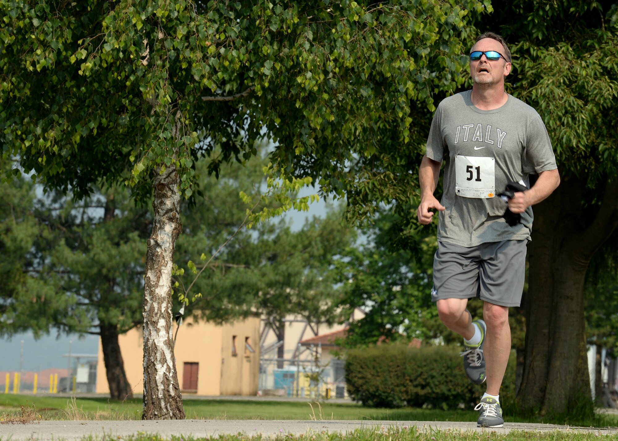 Tony Farrington, 31st Security Forces Squadron, sprints to the finish line to complete Aviano’s 2nd Annual Triathlon, May 30, 2015, at Aviano Air Base, Italy. Approximately 45 people competed in the triathlon, where they swam 500 meters, biked 16 kilometers and ran five kilometers during the race. (U.S. Air Force photo by Airman 1st Class Cary Smith/Released)    