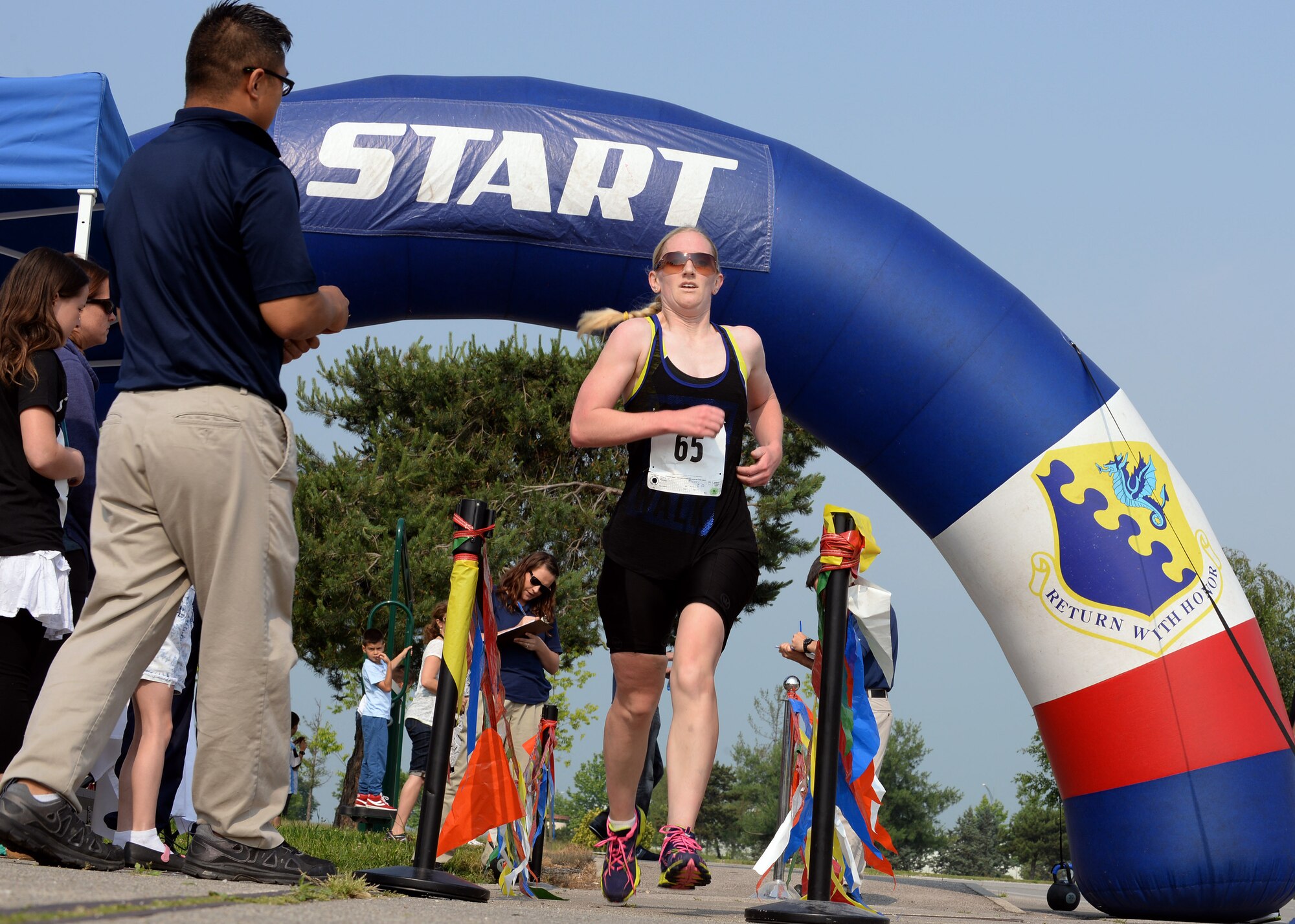 U.S. Air Force Maj. Rachel Weber, 31st Dental Squadron, races through the finish line to complete Aviano’s 2nd Annual Triathlon, May 30, 2015, at Aviano Air Base, Italy. Approximately 45 people competed in the triathlon, where they swam 500 meters, biked 16 kilometers and ran five kilometers during the race. (U.S. Air Force photo by Airman 1st Class Cary Smith/Released)