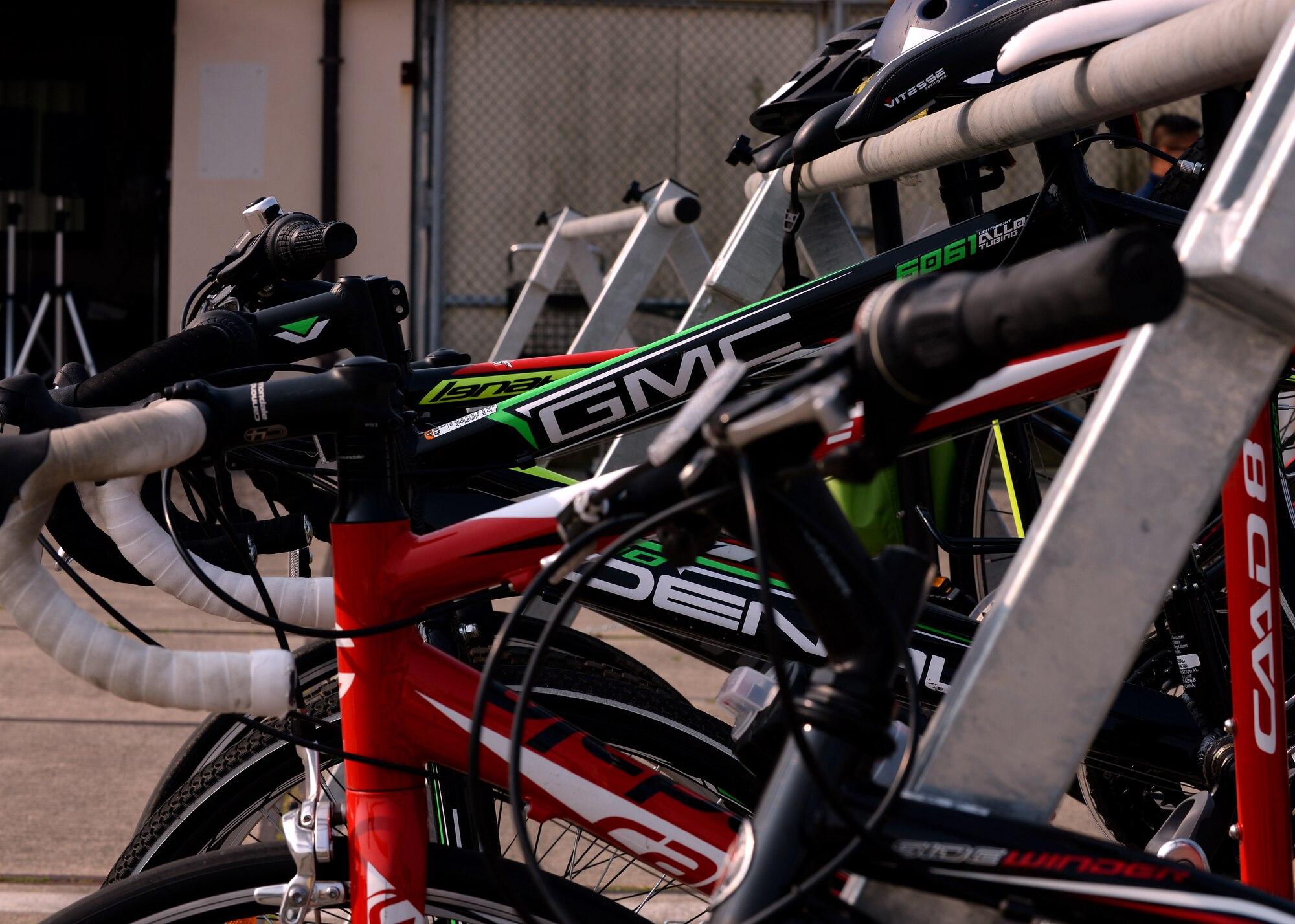 Bicycles rest on racks as competitors finish the five kilometer run portion of the triathlon, May 30, 2015, at Aviano Air Base, Italy. Approximately 45 people competed in Aviano’s 2nd Annual Triathlon, where they swam 500 meters, biked 16 kilometers and ran five kilometers during the race. (U.S. Air Force photo by Airman 1st Class Cary Smith/Released)