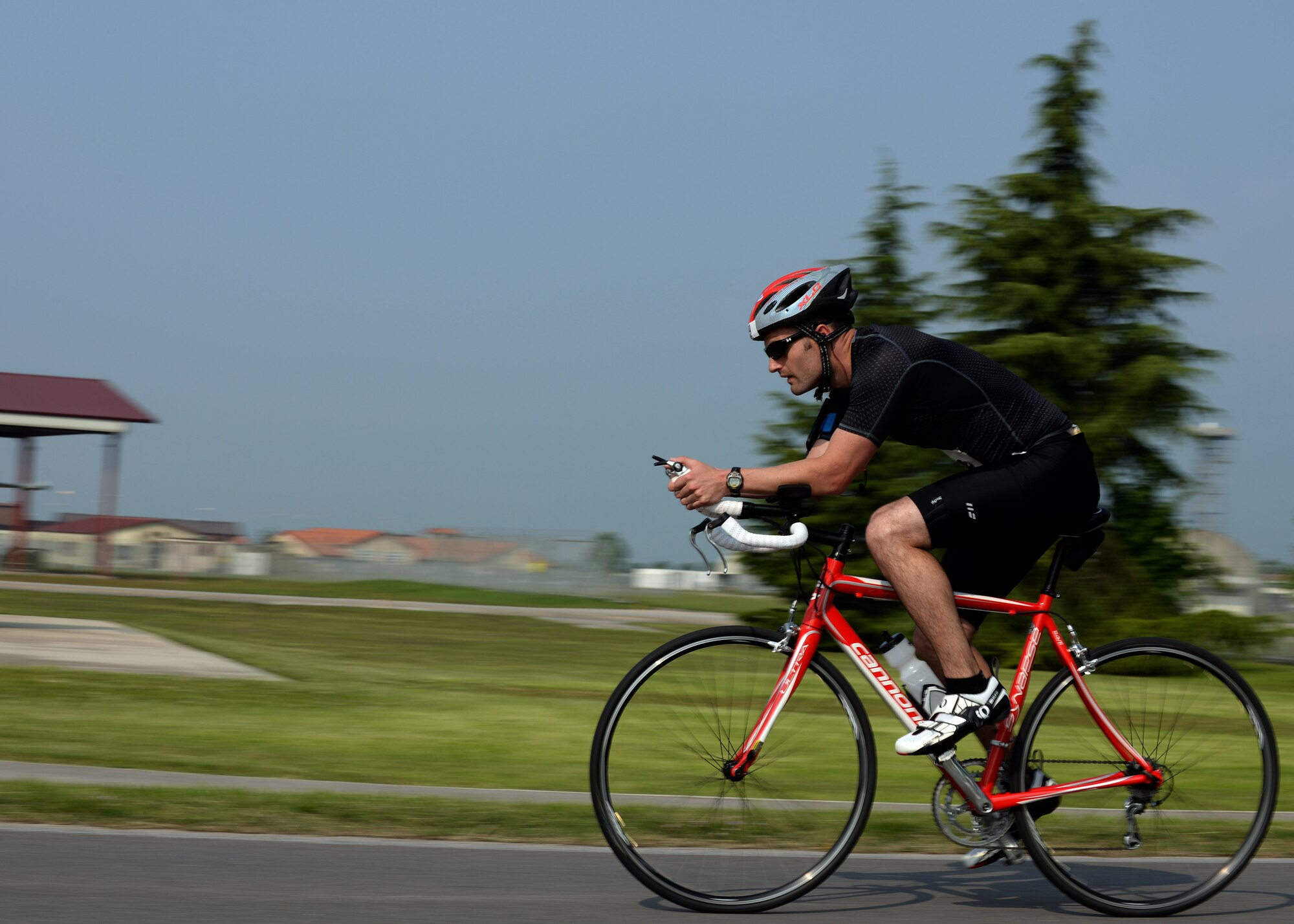 U.S. Air Force Tech. Sgt. Kyle Rollins, 31st Civil Engineer Squadron, pedals along the 16-kilometer route to the next checkpoint, May 30, 2015, at Aviano Air Base, Italy. Approximately 45 people competed in this year’s triathlon, where they swam 500 meters, biked 16 kilometers and ran five kilometers. (U.S. Air Force photo by Airman 1st Class Cary Smith/Released)