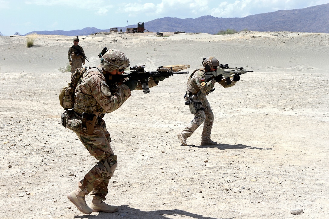 U.S. Army Sgt. Marcus Donaldson, foreground, and a Polish military instructor, advance on their target during partnered marksmanship live-fire training on Tactical Base Gamberi in eastern Afghanistan, May 29, 2015. Donaldson is an infantryman assigned to the 101st Airborne Division.