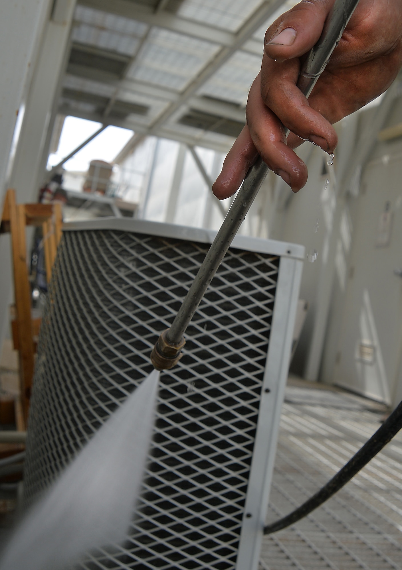 Senior Airman Brandon, heating, ventilation and air conditioning journeyman, pressure washes a split air conditioning unit at an undisclosed location in Southwest Asia May 7, 2015. HVAC Airmen are responsible for installing, operating, maintaining, and repairing heating, ventilation, air conditioning and refrigeration systems, combustion equipment, and industrial air compressors. (U.S. Air Force photo/Tech. Sgt. Jeff Andrejcik)
