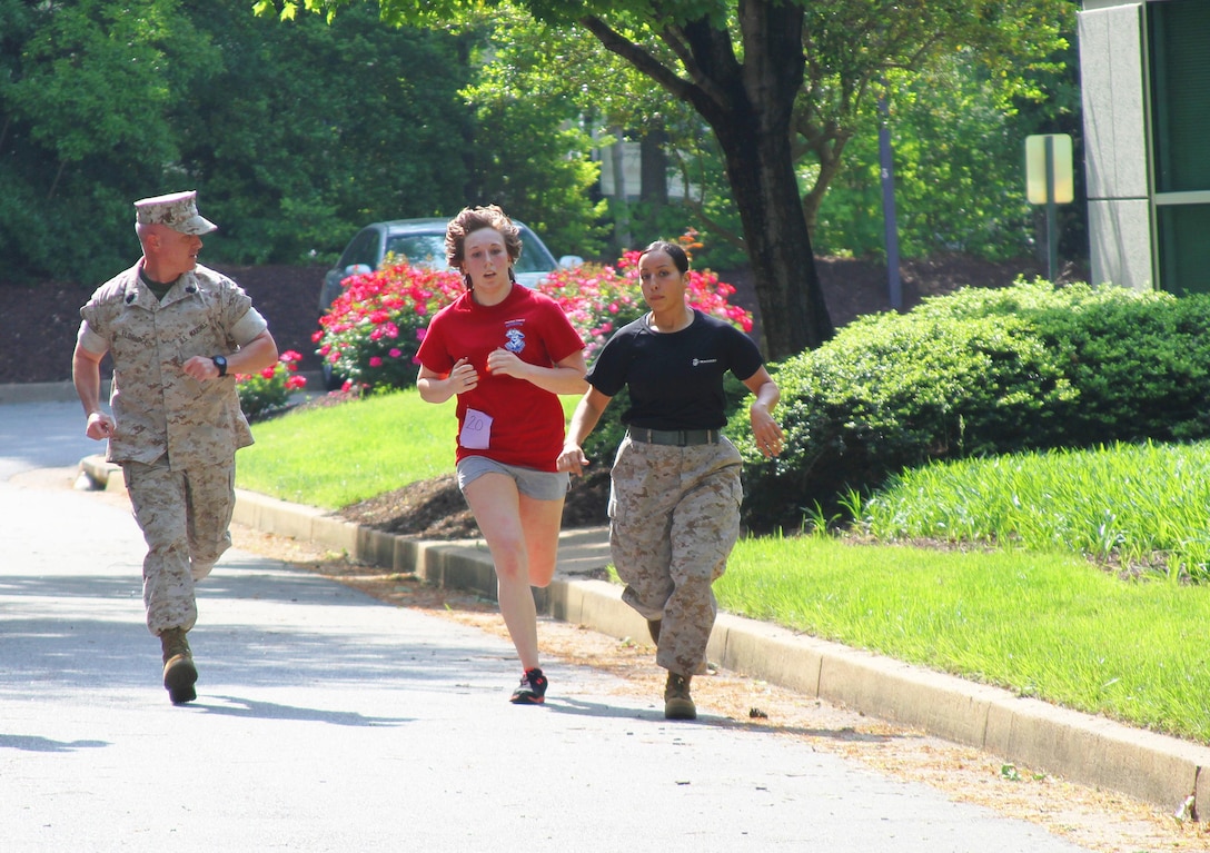 A female member  of Marine Corps Recruiting Station Richmond’s delayed entry program is motivated during the run portion of the initial strength test by Sgt. Maj. David Eldridge, Recruiting Station Richmond’s sergeant major, and Cpl. Kansas Ledezma, Recruiting Station Richmond’s administration clerk, and a native of Buckhannon, West Virginia, during the station’s annual female pool function. The event gave the female poolees an opportunity to learn what they can expect aboard Marine Corps Recruit Depot Parris Island, as they undergo the longest and most difficult boot camp within the U.S. armed services to earn the coveted title of United States Marine.