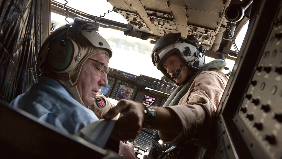 One of the pilots of an MV-22 Osprey straps Secretary of Defense Ash Carter into his seat before surveying the Straits of Malacca off the coast of Singapore, May 29, 2015.