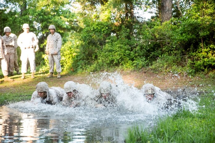 Marines with Electronics Maintenance Company, 2nd Maintenance Battalion, low-crawl through water during the endurance course at the Battle Skills Training School aboard Camp Lejeune, N.C., May 29, 2015. ELMACO hiked approximately two miles to the school and then conducted the course to build camaraderie and say farewell to their commanding officer, Maj. Brian L. White. (U. S. Marine Corps photo by Cpl. Shawn Valosin)