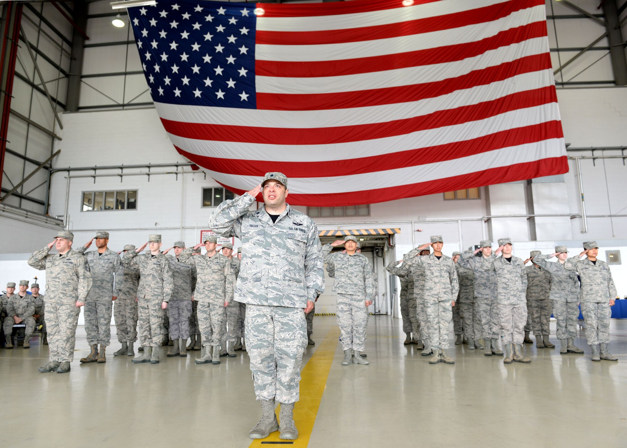 U.S. Lt. Col. William Julian, 352nd Special Operations Support Squadron director of operations, leads the formation's salute rendered during the playing of the U.S. and U.K. national anthems just prior to the 67th Special Operations Squadron change of command ceremony May 29, 2015, in Hangar 803 on RAF Mildenhall, England. The ceremony is a time-honored tradition in which one officer relinquishes command and passes it to another.(U.S. Air Force photo by Senior Airman Christine Halan)