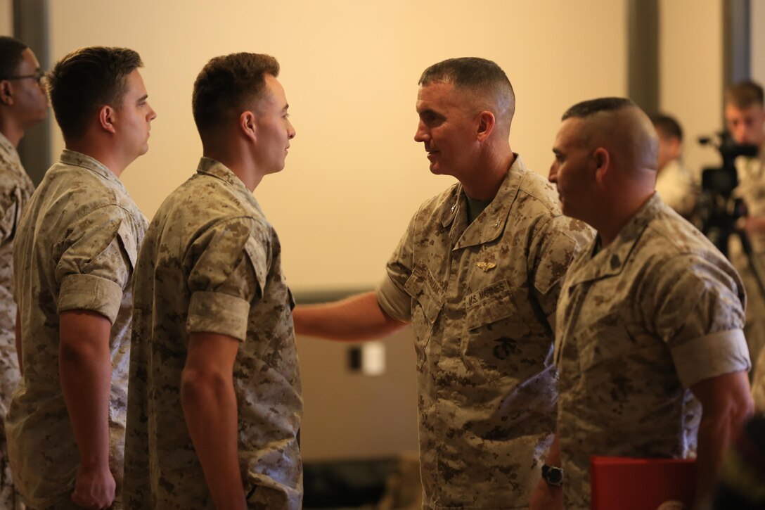 Col. John Farnam, Marine Corps Air Station Miramar commanding officer, and Sgt. Maj. Richard Charron, MCAS Miramar sergeant major, present awards to Marines and Sailors with MCAS Miramar during a Noncommissioned Officer, Marine and Sailors of the Quarter awards ceremony aboard the installation, June 2. The Marines and Sailors were awarded for their outstanding performance. Representatives from outlets such as GEICO and Navy Federal Credit Union showed their thanks and support with gifts for those awarded at the ceremony.