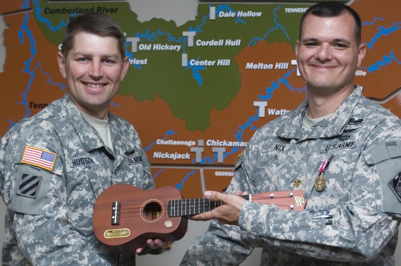 Lt. Col. John L. Hudson (Left), U.S. Army Corps of Engineers Nashville District commander, presents Maj. Timothy E. Nix with a ukulele May 14, 2015 as a symbol of his time working with the Nashville District in Music City.  Nix worked primarily as a project engineer on the $19.5 million site preparation work at the Y-12 National Security Complex in Oak Ridge, Tenn. The Corps began construction in June 2013 and culminated its work in January 2015.