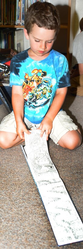 A child reads his favorite book in the Children's Library Room at Marine Corps Logistics Base Albany's Library during the 2015 Summer Reading Program, June 3. This year's program is themed "Read to the Rhythm."