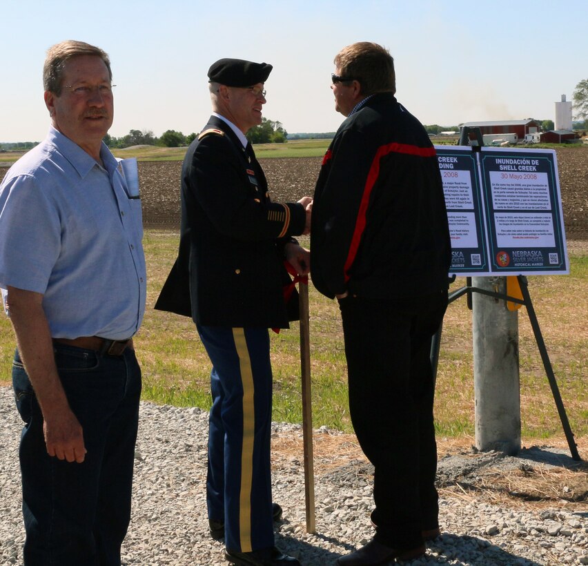 City of Schuyler Mayor David Reinecke basks in the glory of his city's new levee, while USACE Omaha District Commander Col. Joel Cross shakes hands with Mike Murren from the Lower Platte North Natural Resources District.