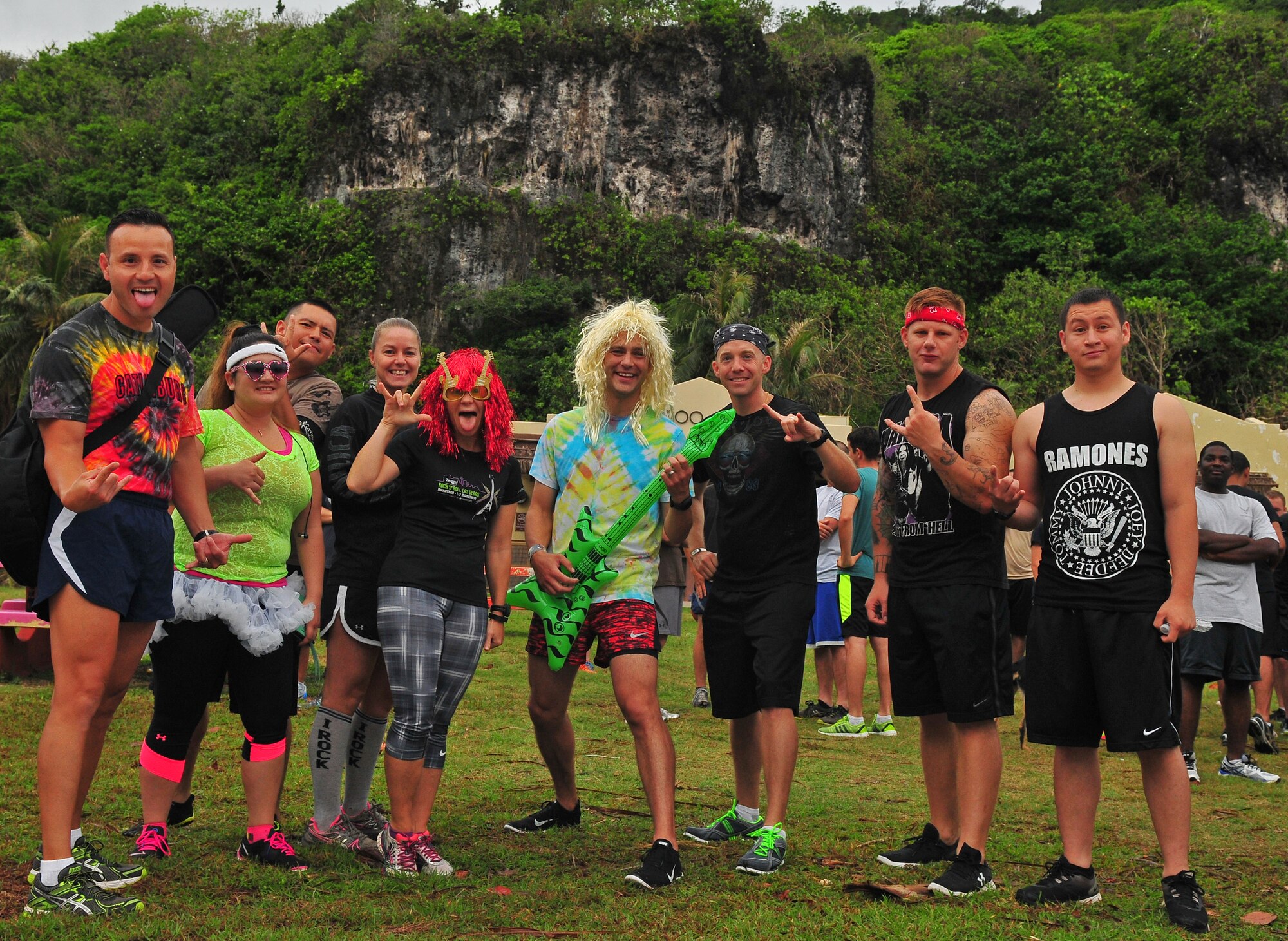 Runners wearing rock ‘n’ roll costumes smile for a photo before the start of a 5K race June 3, 2015, at Tarague Beach on Andersen Air force Base, Guam. The athletes competed in the rock-music themed Rock ‘n’ Roll 5K run, organized by the 36th Force Support Squadron. (U.S. Air Force photo by Senior Airman Alexander W. Riedel/Released)