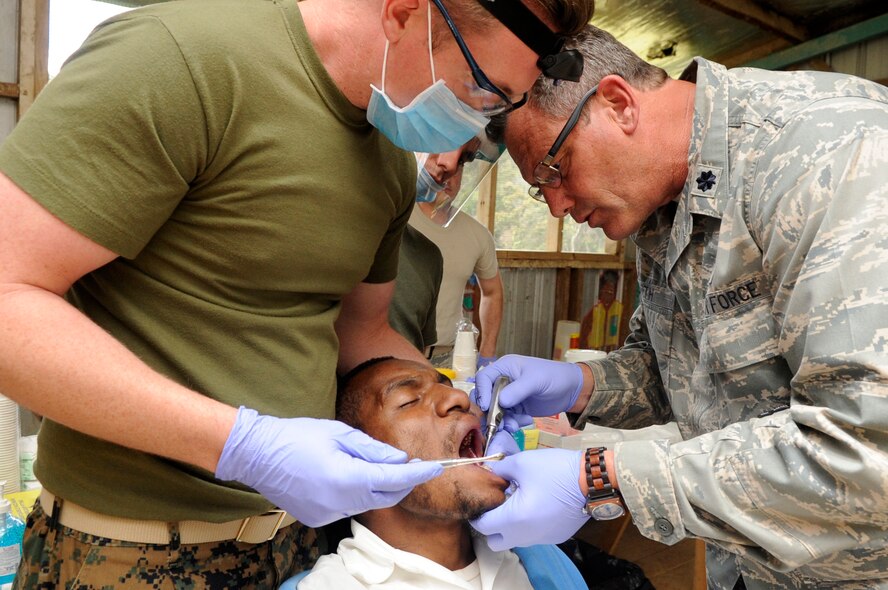 U.S. Navy Lt. John Greiner, from Camp Pendleton, Calif., 1st Dental Battalion general dentist, and U.S. Air National Guard Lt. Col. Michael Smith 162nd Medical Group, general dentist from Tucson, Ariz., remove a broken and infected tooth from a local???s mouth during Pacific Angel 15-4, Papua New Guinea, May 31, 2015. Pacific Angel is an annual joint humanitarian assistance mission that is designed to bring humanitarian civic assistance and combined civil-military operations to the Pacific region. (U.S. Air Force photo by Staff Sgt. Marcus Morris/Released)