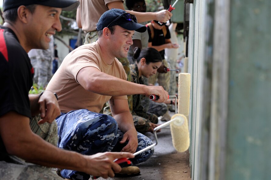 Military members from the U.S., New Zealand and Australia paint Iufi-Iufa Primary School during Pacific Angel at Asaro District, Papau New Guinea, May 30, 2015. Pacific Angel is a U.S Pacific Command multilateral humanitarian assistance civil military operation, which improves military-to-military partnerships in the Pacific while also providing medical health outreach, civic engineering projects and subject matter exchanges among partner forces. (U.S. Air Force photo by Staff Sgt. Marcus Morris/Released)