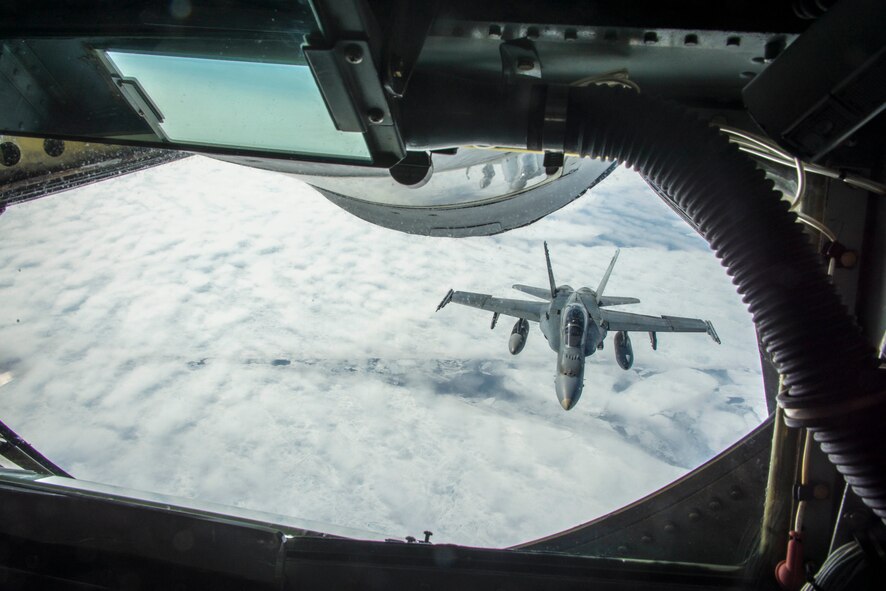 A Royal Canadian Air Force CF-18 Hornet pilot flies up near the boom pod on a 22nd Air Refueling Wing KC-135 Stratotanker from McConnell Air Force Base, Kan., to thank the 92nd Air Refueling Wing crew from Fairchild AFB, Wash., for the successful aerial refueling during exercise AMALGAM DART 15-2 May 29, 2015, over the Arctic Ocean. AMALGAM DART spanned two forward operating locations in Canada’s Northwest Territory, two U.S. Air Force bases in Alaska and a mobile radar site in Resolute, Nunavut, as well as, the sky over much of the North American Aerospace Defense Command’s area of responsibility. (U.S. Air Force photo/Staff Sgt. Benjamin W. Stratton)
