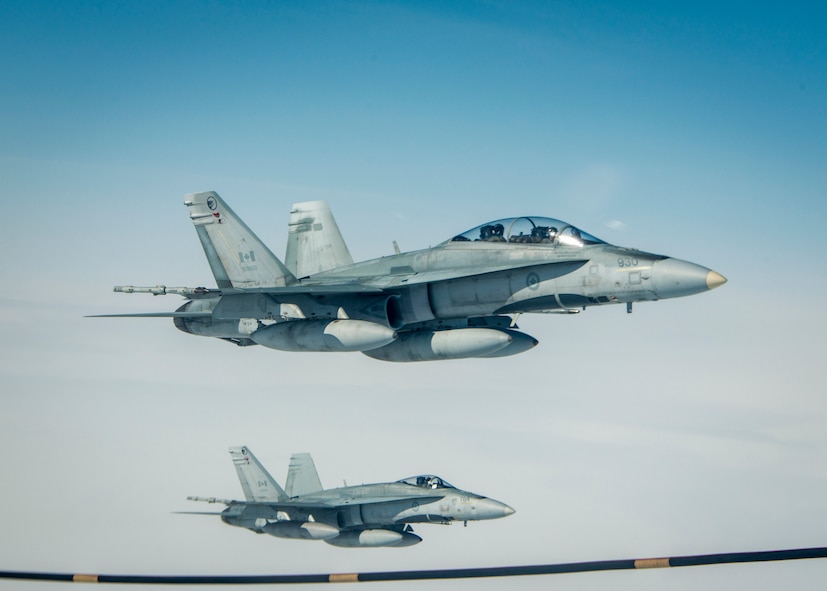 Royal Canadian Air Force CF-18 Hornets fly alongside a 22nd Air Refueling Wing KC-135 Stratotanker from McConnell Air Force Base, Kan., operated by a 92nd Air Refueling Wing crew from Fairchild AFB, Wash., as the CF-18s each take turns refueling from a multi-point refueling system pod during exercise AMALGAM DART 15-2 May 29, 2015, over the Arctic Ocean. These pod modifications enhance the efficiency and flexibility of the Air Force's aerial refueling fleet, enabling KC-135s to refuel NATO and U.S. Navy aircraft. (U.S. Air Force photo/Staff Sgt. Benjamin W. Stratton)
