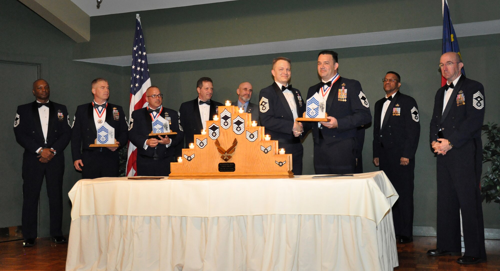 Chief Master Sgt. Joseph Braden, 916th Aircraft Maintenance Squadron, receives a promotion plaque from Chief Master Sgt. James Loper, 916th Air Refueling Wing command chief, during an NCO induction ceremony held at Walnut Creek Country Club, May 2, 2015. Braden, the wing’s newest chief, was joined by Chief Master Sergeants William Delaughter and Karl Wolf, both promoted within the last year, as well as all other chiefs in attendance. (U.S. Air Force photo/Staff Sgt. Alan Abernethy)