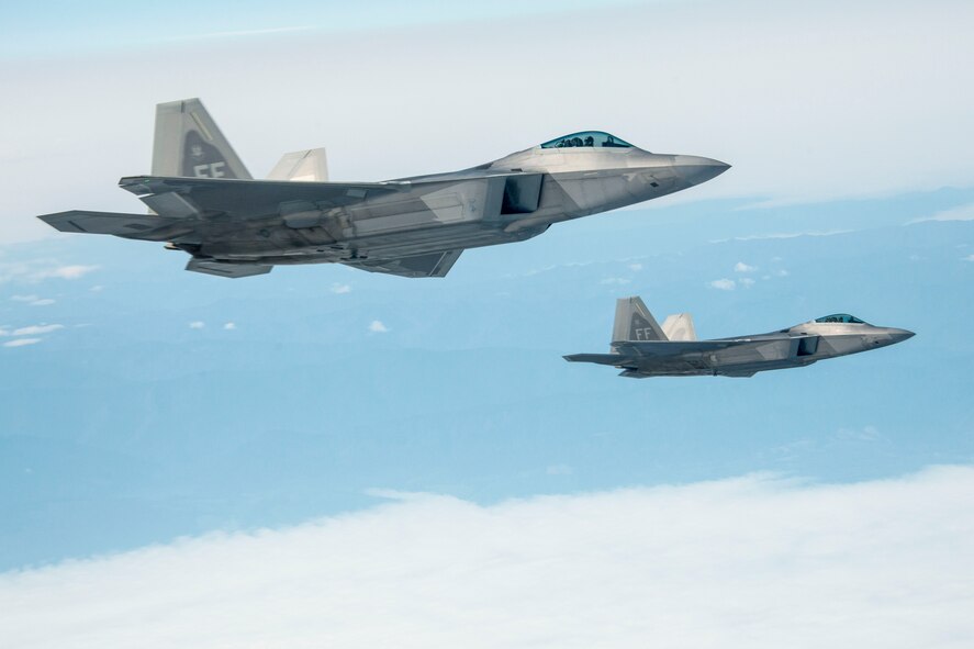 Two F-22 Raptors from the 1st Fighter Wing at Joint Base Langley-Eustis escort a 92nd Air Refueling Wing KC-135 Stratotanker from Fairchild AFB, Wash., on their way to exercise AMALGAM DART 15-2 May 27, 2015, over British Columbia, Canada. The F-22 Raptor is the Air Force's newest fighter aircraft. Its combination of stealth, supercruise, maneuverability, and integrated avionics, coupled with improved supportability, represents an exponential leap in warfighting capabilities. The Raptor performs both air-to-air and air-to-ground missions allowing full realization of operational concepts vital to the 21st century Air Force. (U.S. Air Force photo/Staff Sgt. Benjamin W. Stratton)