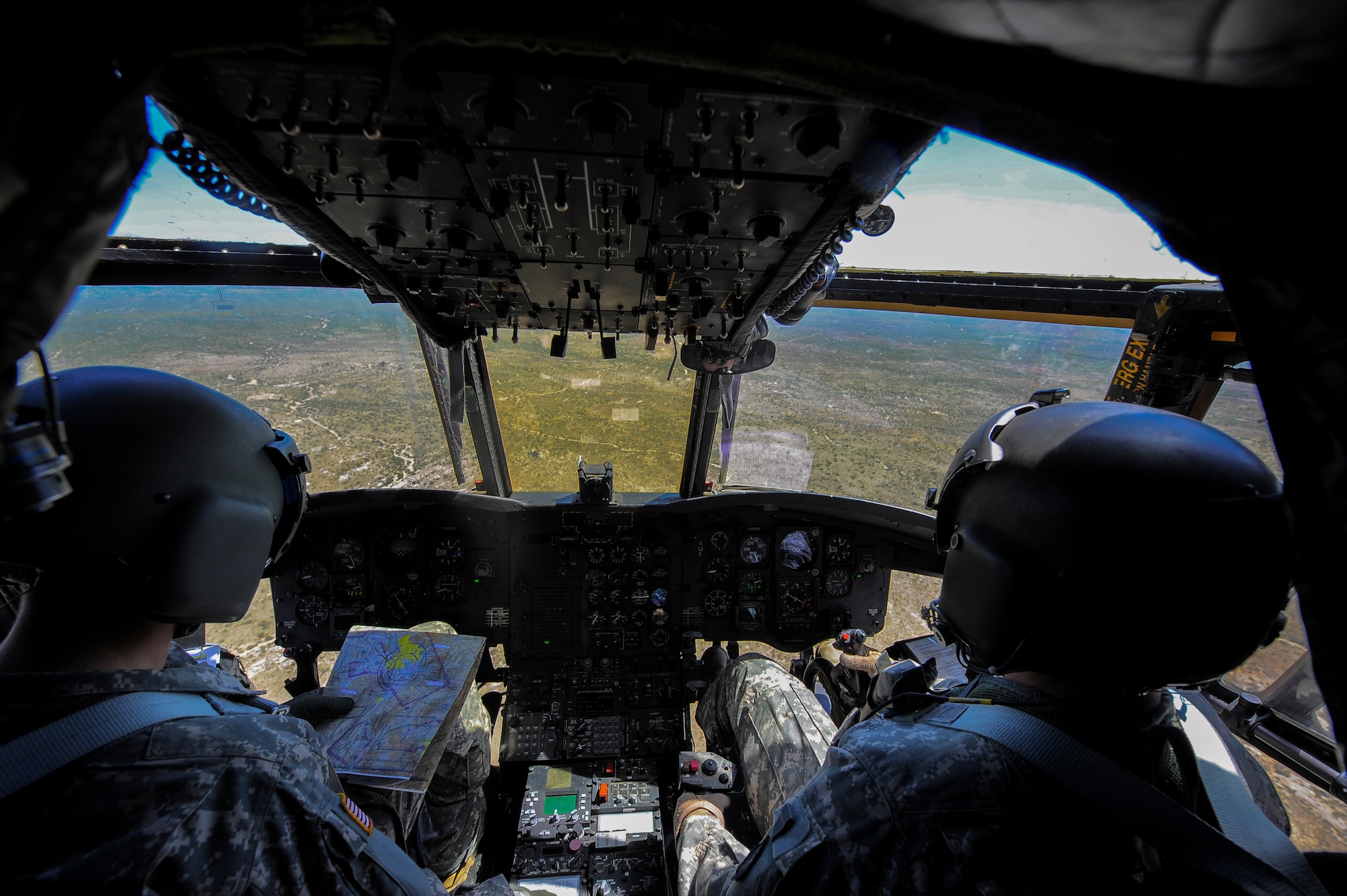 U.S. Army 1st Lt. Erik Poser, Task Force Tatanka CH-47D Chinook pilot, reads an Sectional Aeronautical Chart while Capt. Drew Rowland, Task Force Tatanka CH-47D Chinook pilot commands a CH-47D while flying over southern Arizona during Angel Thunder 2015, June 2, 2015. Angel Thunder is the largest personnel recovery exercise in the world combining joint, coalition and interagency personnel. Participants will train through the full spectrum of personnel recovery capabilities with numerous types of aircraft.(U.S. Air Force photo by Staff Sgt. Angela Ruiz/Released) 