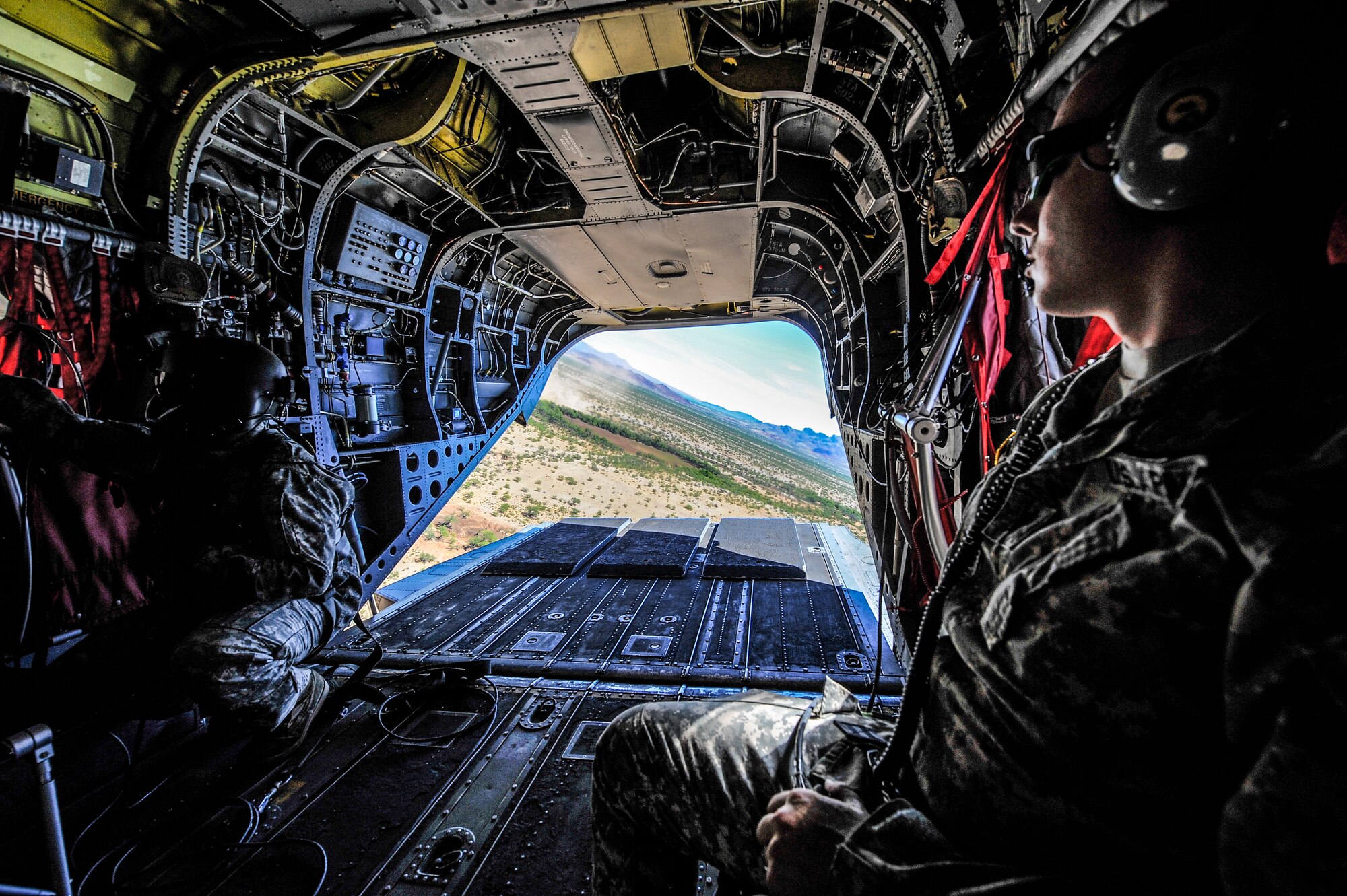 U.S. Army Staff Sgt. Westly Vincent, Task Force Tatanka, CH-47D Chinook flight engineer, and 1st Lt. Sebastien Guilhemotonia secure themselves as a CH-47D takes off from the at Ruby Fuzzy MOA, Ariz., during Angel Thunder 2015, June 2, 2015. Angel Thunder is the world’s largest personnel recovery exercise, hosting 11 partner nations and nine inter-agencies with a common goal to train personnel recovery forces to prepare, plan, execute and adapt for a rescue mission. (U.S. Air Force photo illustration by Staff Sgt. Angela Ruiz/Released) 