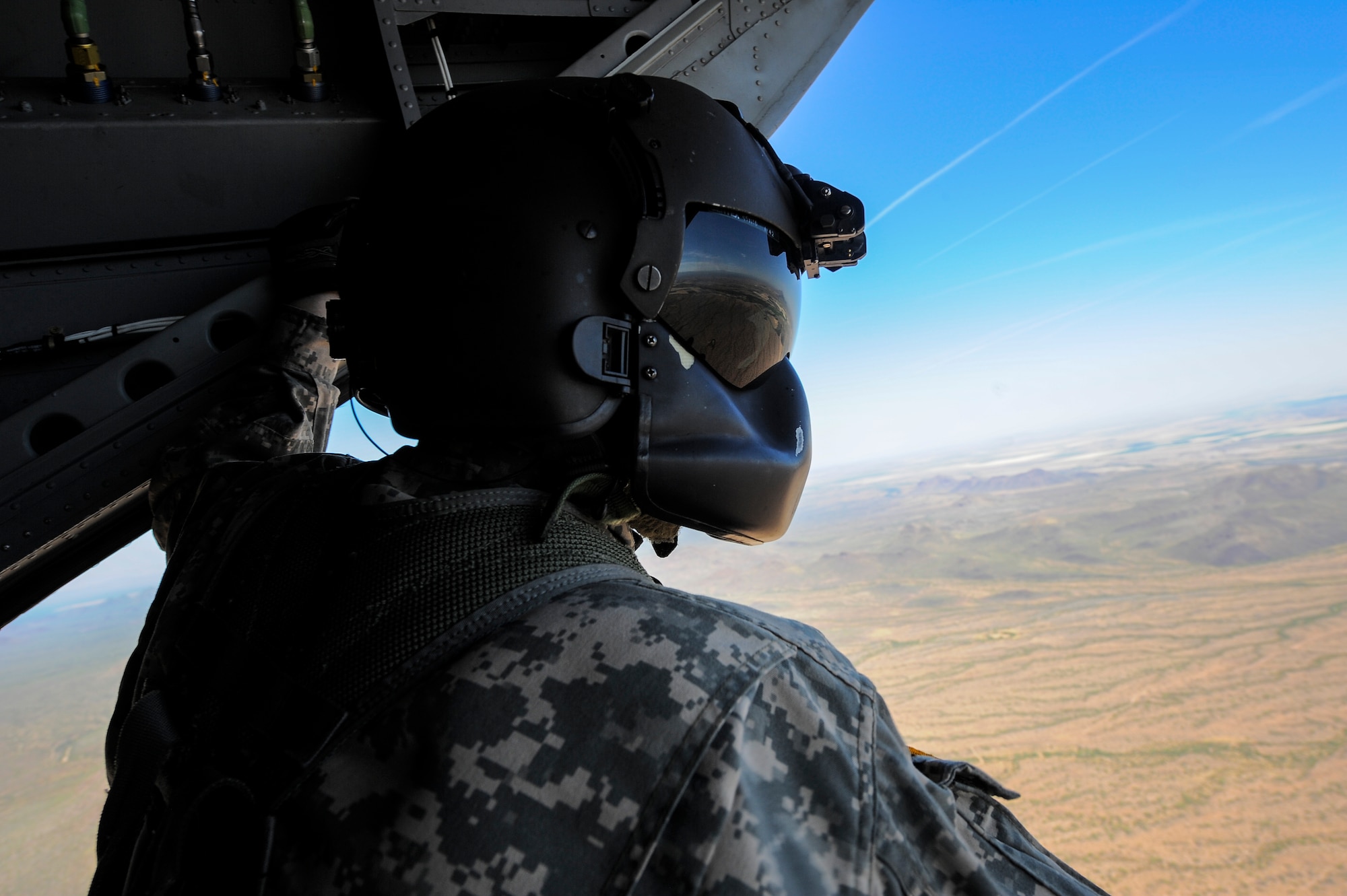 U.S. Army Staff Sgt. Westly Vincent, Task Force Tatanka, CH-47D Chinook flight engineer, conducts airspace surveillance on the back of a CH-47D while flying over southern Arizona during Angel Thunder 2015, June 2, 2015. Angel Thunder is hosted by the 355th Fighter Wing at Davis-Monthan Air Force Base, Ariz., but many flying operation will extend throughout Arizona, New Mexico and California.  (U.S. Air Force photo by Staff Sgt. Angela Ruiz/Released)