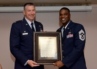 ALTUS AIR FORCE BASE, Okla. – U.S. Air Force Col. Bill Spangenthal, 97th Air Mobility Wing commander, and U.S. Air Force Chief Master Sgt. James Powell, 97th AMW command chief, hold an Order of the Spear Proclamation during a ceremony, June 3, 2015. Spangenthal was inducted into the Order of the Spear which is the highest honor that can be bestowed upon a leader by the enlisted members of the 97th Air Mobility Wing. (U.S. Air Force photo by Senior Airman Franklin R. Ramos/Released)