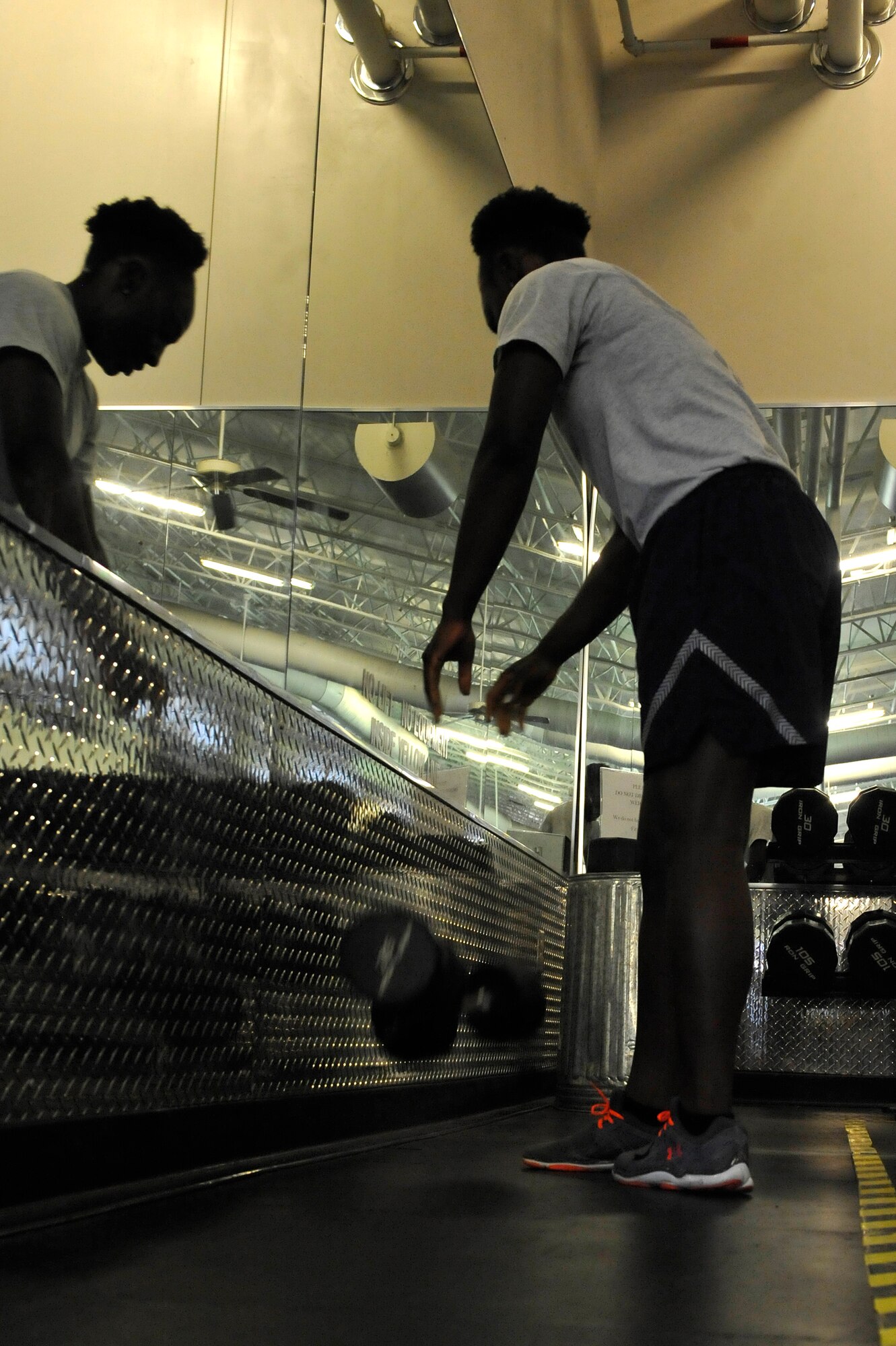 U.S. Air Force Tech. Sgt. Jessica Covington, 633rd Force Support Squadron fitness center non-commissioned officer in charge, drops her weights inside the yellow line at the Shellbank Fitness Center on Langley Air Force Base, Va., June 1, 2015. Dropping weights inside the line can cause damage to the mirrors and weights. (U.S. Air Force photo by Senior Airman Breonna Veal/Released)