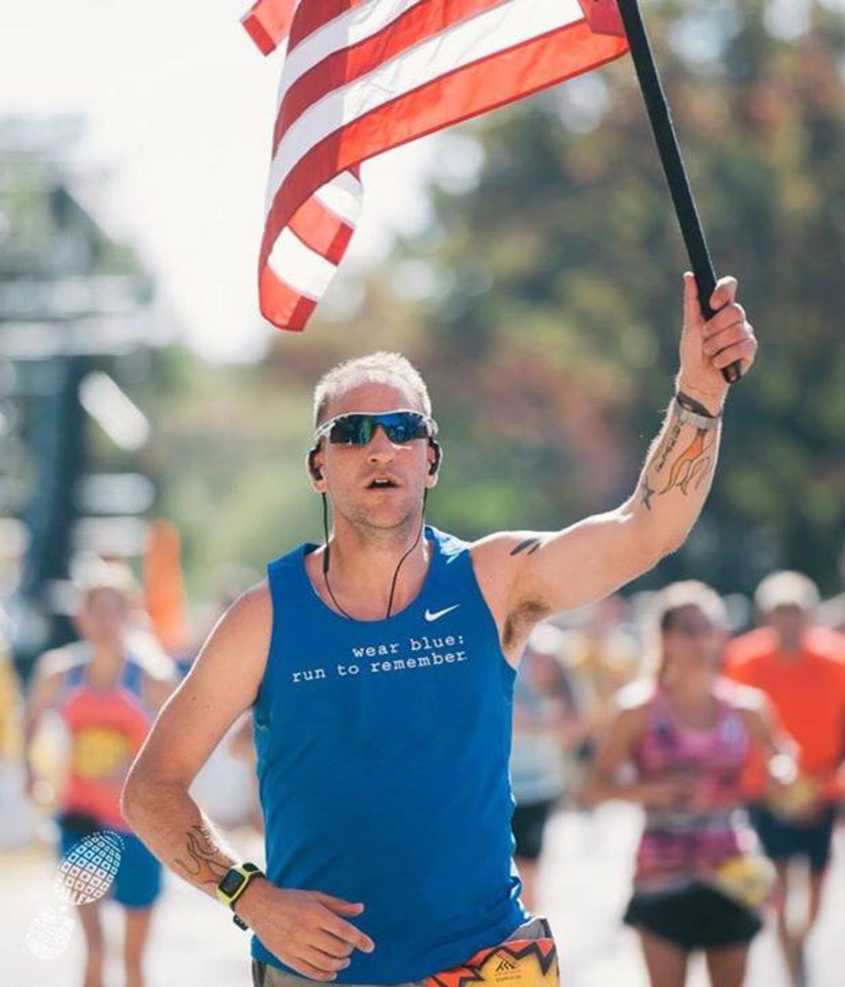 U.S. Army Staff Sgt. Jeffery Lewis, Charlie Company, 1st Battalion, 222nd Aviation Regiment platoon sergeant, carries a flag during the Marine Corp Marathon in Arlington, Va., Oct. 26, 2014.  Lewis held the flag for the entirety of the marathon, 26.2 miles, to pay tribute to fallen Service members and their families. (U.S. Air Force photo courtesy photo)