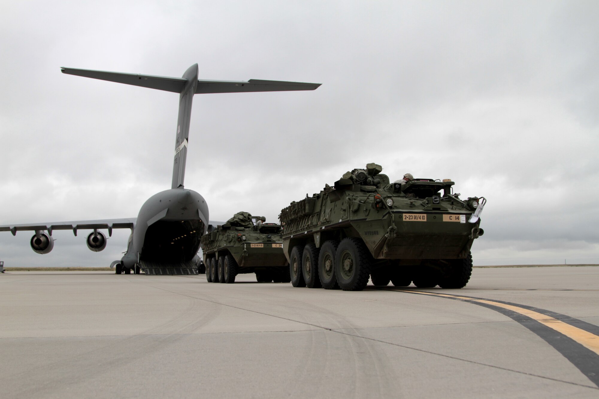 Two Strykers from 2nd Battalion, 23rd Infantry Regiment, 1st Stryker Brigade Combat Team, 4th Infantry Division, are parked outside of a C-17 Globemaster III from the 21st Airlift Squadron during air load operations in preparation for a flight to the National Training Center at Fort Irwin, Calif., May 21, 2015. The Soldiers deployed to the major training area located in the Mojave Desert to act as the opposing force for visiting military unit training.