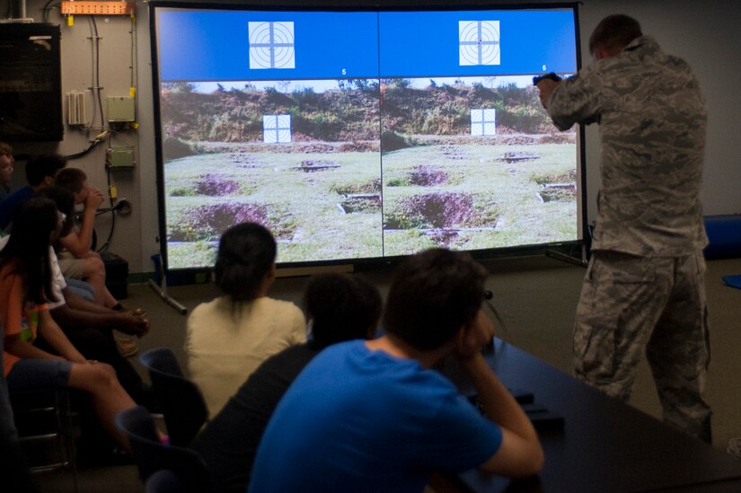 U.S. Air Force Staff Sgt. Jacob Brown, 633rd Security Force Squadron, demonstrates the virtual range simulator capabilities for students from Hampton Roads area high schools during a tour at Langley Air Force Base, Va., May 29, 2015. During the tour, Airmen from across three wings gave the students a first-hand glimpse into the day-to-day operations of the diverse missions at Langley. (U.S. Air Force photo by Senior Airman R. Alex Durbin/Released)