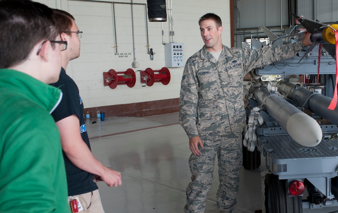 U.S. Air Force Senior Airman Garrett Peak, 1st Maintenance Squadron precision guided munitions inspector, explains munition GPS systems to high schools students from the Hampton Roads area while on a mission orientation tour at Langley Air Force Base, Va., May 29, 2015. The students visited multiple units across Langley to learn about the Air Force mission and the installation’s impact across the globe. (U.S. Air Force photo by Senior Airman R. Alex Durbin/Released)