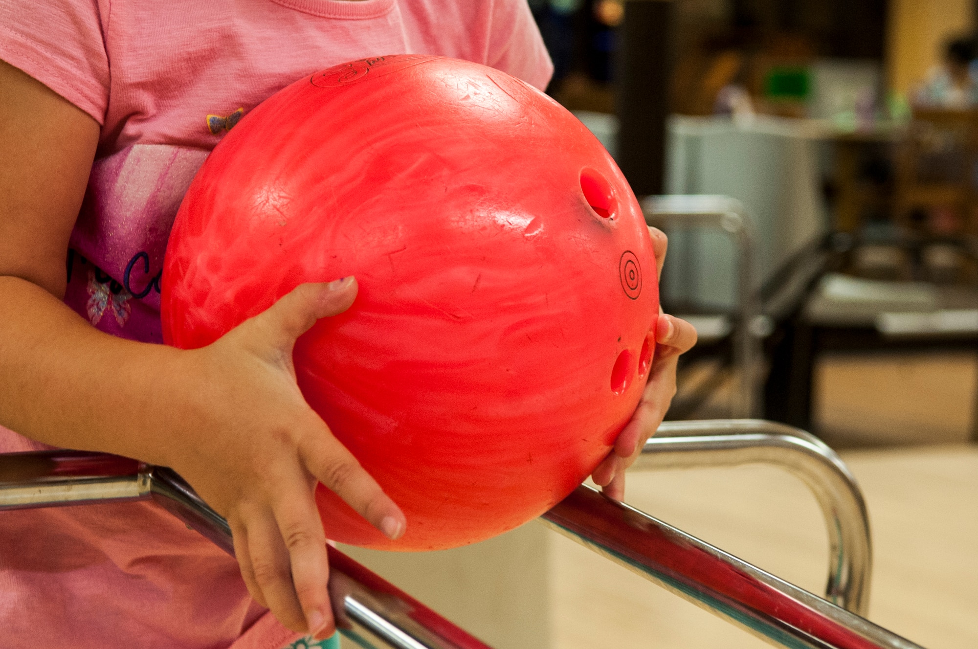Child of Stephanie Melvin and Maj. James Melvin, 4th Civil Engineer Squadron chief of operations, begins to release a bowling ball, June 3, 2015, at Seymour Johnson Air Force Base, North Carolina. Planet Bowl added new flooring, furnishings and a handicap area for customers. (U.S. Air Force photo/Airman Shawna L. Keyes)