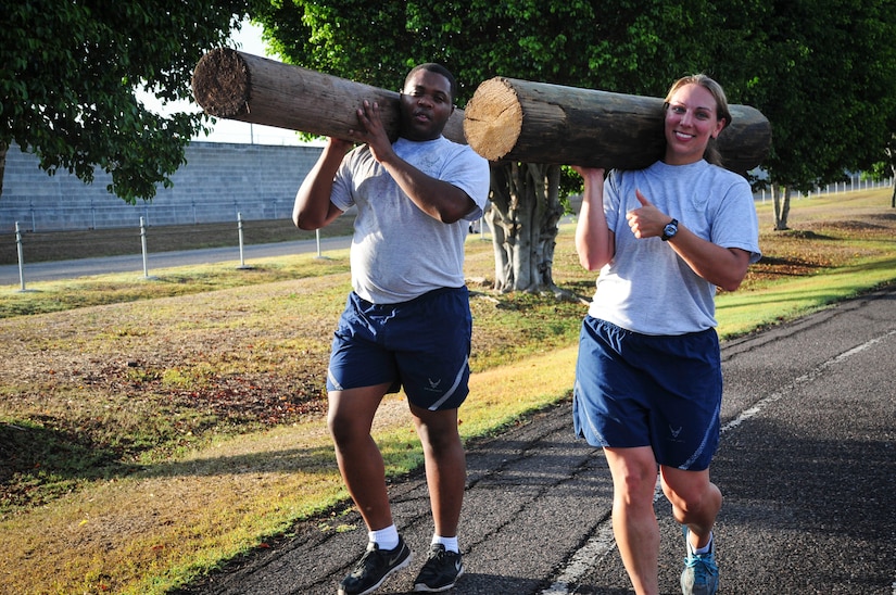 Capt. Jerrel Scriven, Joint Task Force-Bravo director of protocol, and Capt. Laura Miller, JTF-B adjutant, carry logs around the track at Soto Cano Air Base, Honduras, June 03, 2015. This is one of many exercises in the grueling workout known as “Sgt. Maj. PT,” a training session led JTF-B’s Command Sgt. Maj., Nelson Callahan, that encourages members to “lead by example, to break a sweat, to blast [their] core and to build unit cohesion” (U.S. Air Force photo by Capt. Christopher Love).
