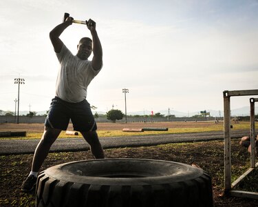 Capt. Jerrel Scriven, Joint Task Force-Bravo director of protocol, swings a sledge hammer into a tire for strength training June 03, 2015, at Soto Cano Air Base, Honduras. This is one of many exercises in the grueling workout known as “Sgt. Maj. PT,” a training session led JTF-B’s Command Sgt. Maj., Nelson Callahan, that encourages members to “lead by example, to break a sweat, to blast [their] core and to build unit cohesion” (U.S. Air Force photo by Capt. Christopher Love).