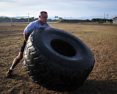 Command Sgt. Maj. Nelson Callahan, Joint Task Force-Bravo Command Sgt. Maj., flips a tire as part of a physical training session June 03, 2015, at Soto Cano Air Base, Honduras. A dedicated athlete and mentor, CSM Callahan invites others to join him during this specialized physical training session so they can “lead by example…break a sweat…blast [their] core and…build unit cohesion” (U.S. Air Force photo by Capt. Christopher Love). 