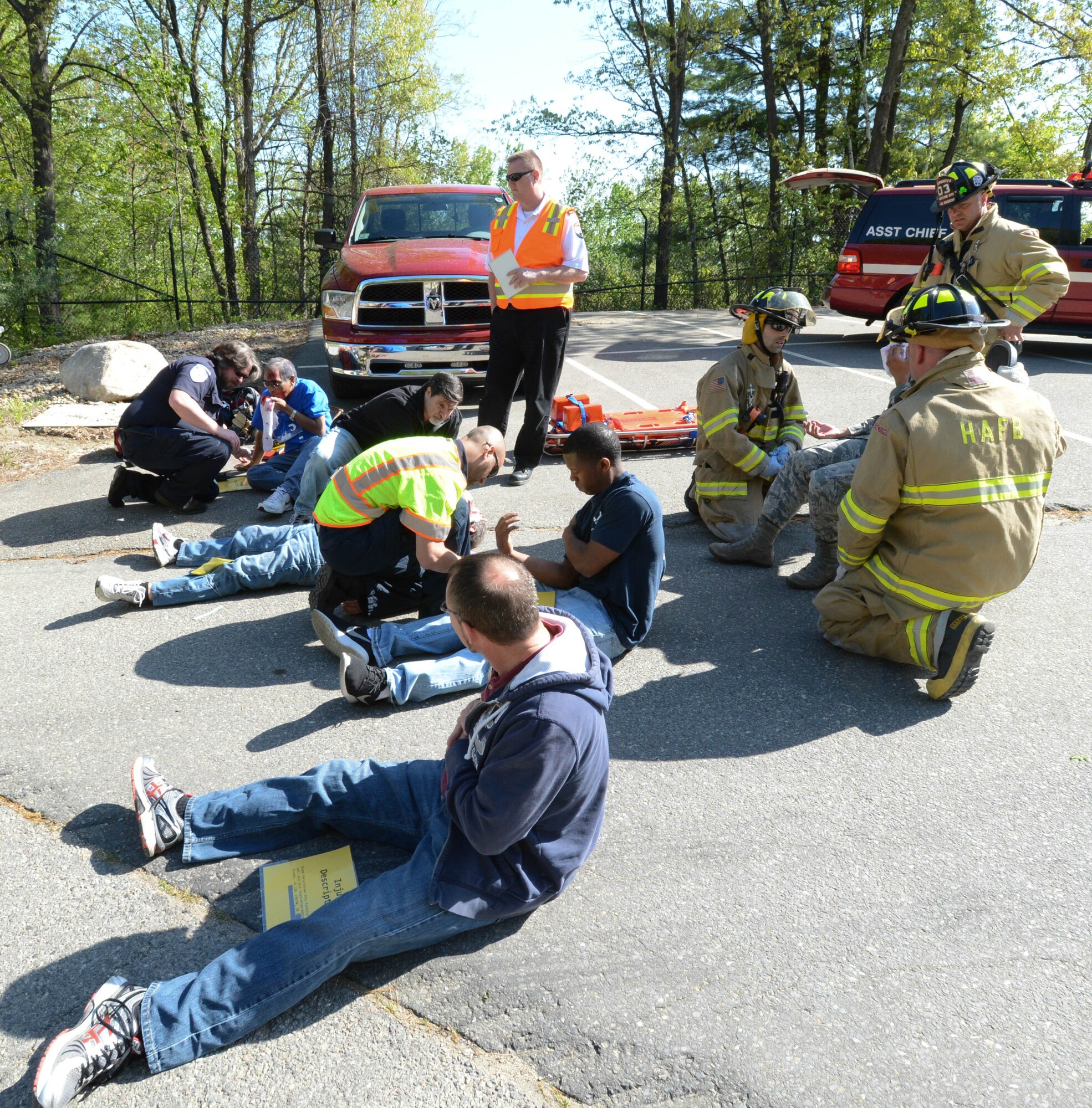 First responders assess conditions of role-playing ‘patients’ during a base readiness exercise at Hanscom Air Force Base, Mass., May 14, while an inspector watches. The exercise was part of the recent Unit Effectiveness Inspection and allowed inspectors to evaluate how Hanscom runs its exercises. (U.S. Air Force photo by Jerry Saslav)
